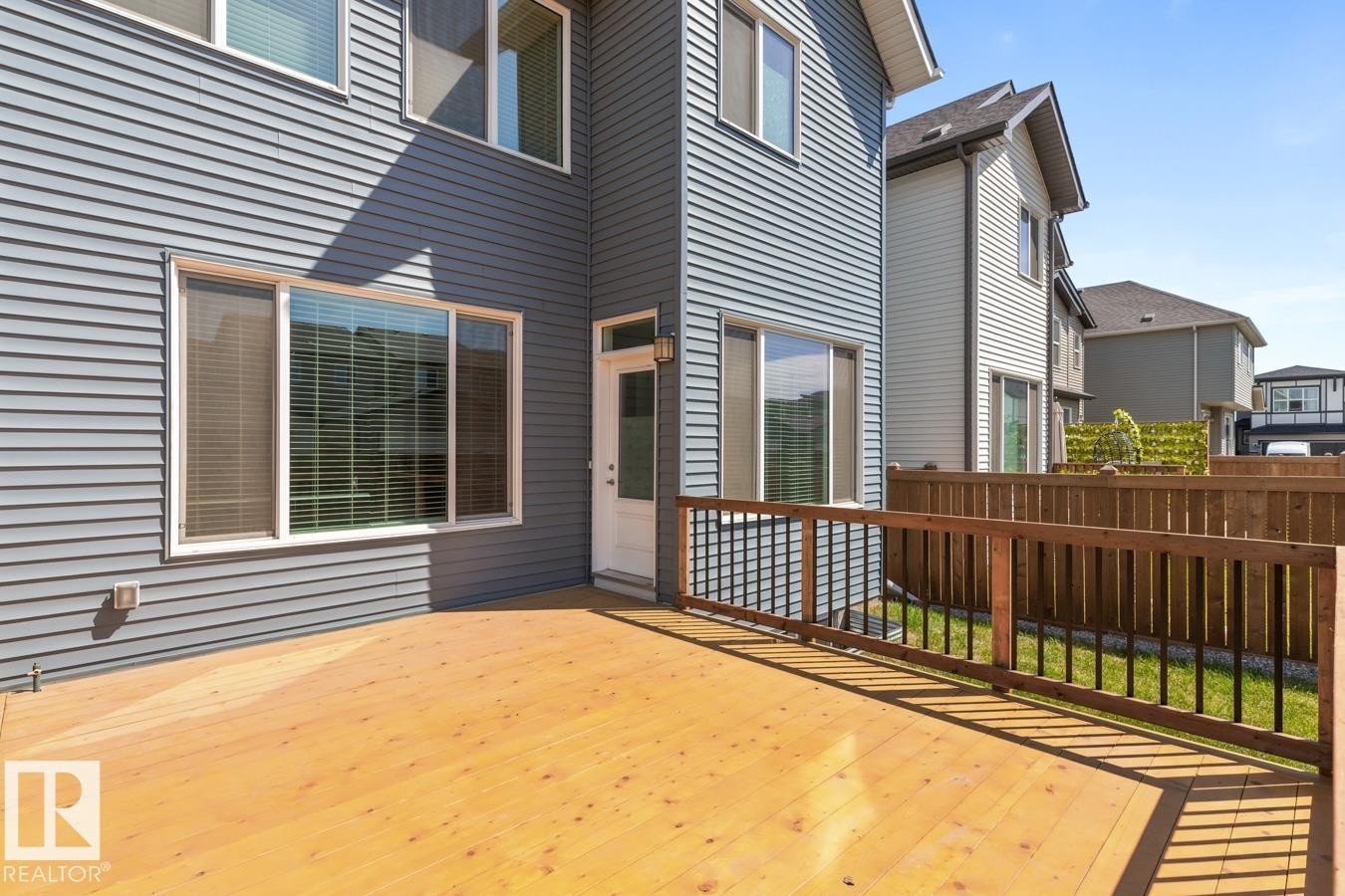 Spacious exterior deck with wood flooring and a contrasting wood and metal railing - 117 Paisley Gate Gate, Edmonton, AB