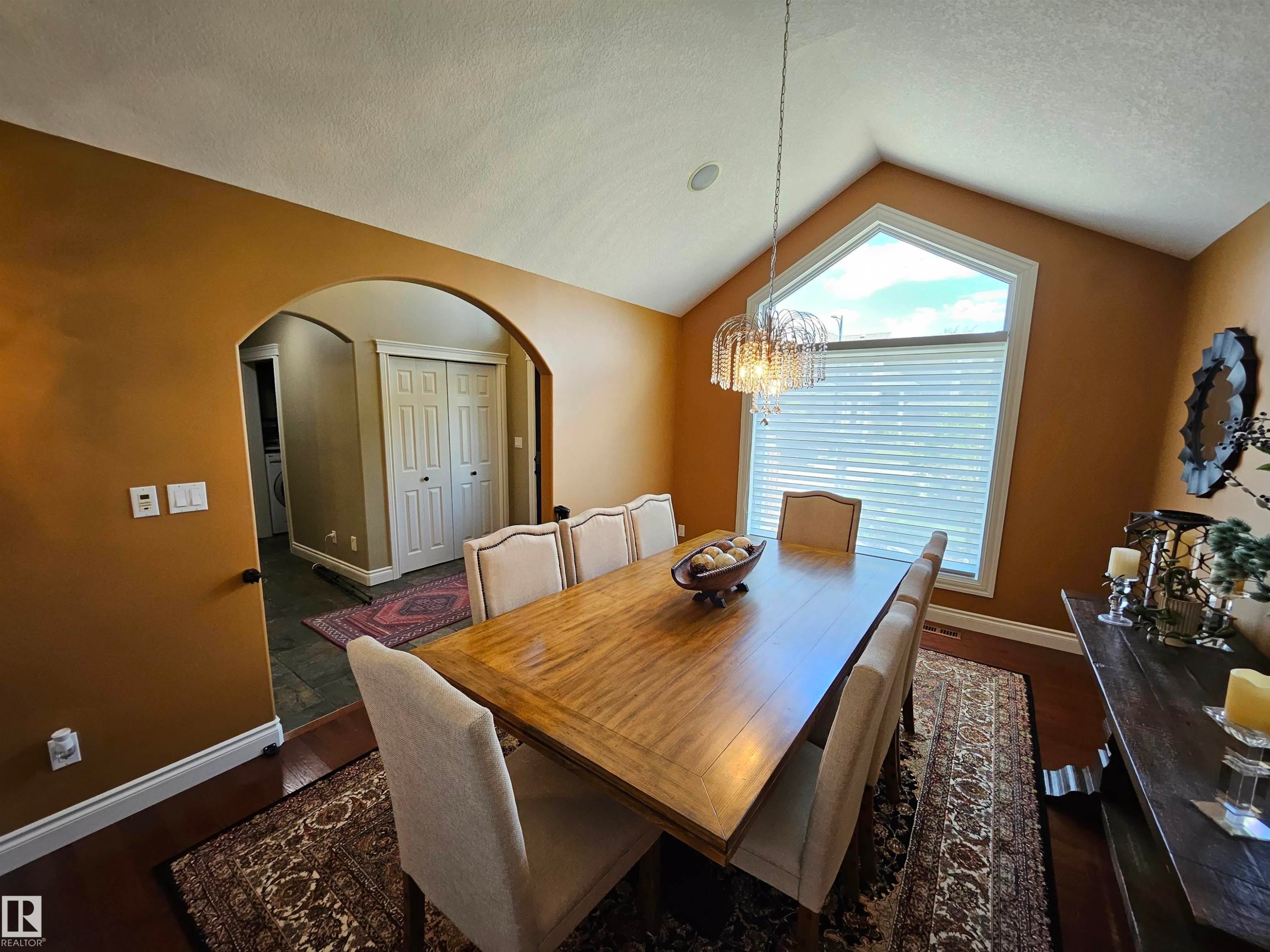 Dining space featuring a vaulted ceiling and an arched window - 2322 Rutherford Way, Edmonton, AB