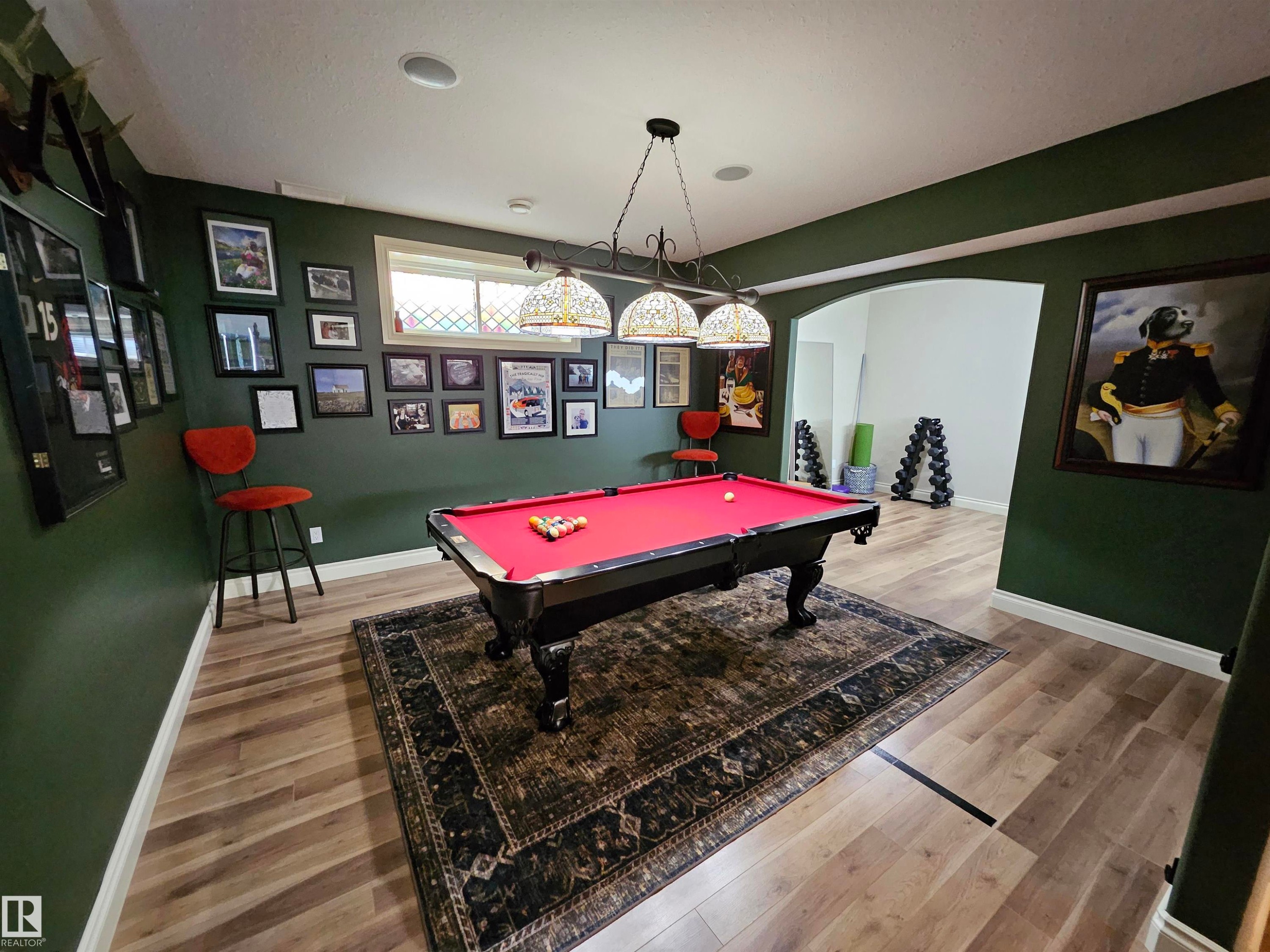 Recreation room featuring wood-finish flooring, recessed lighting, and an arched entryway - 2322 Rutherford Way, Edmonton, AB