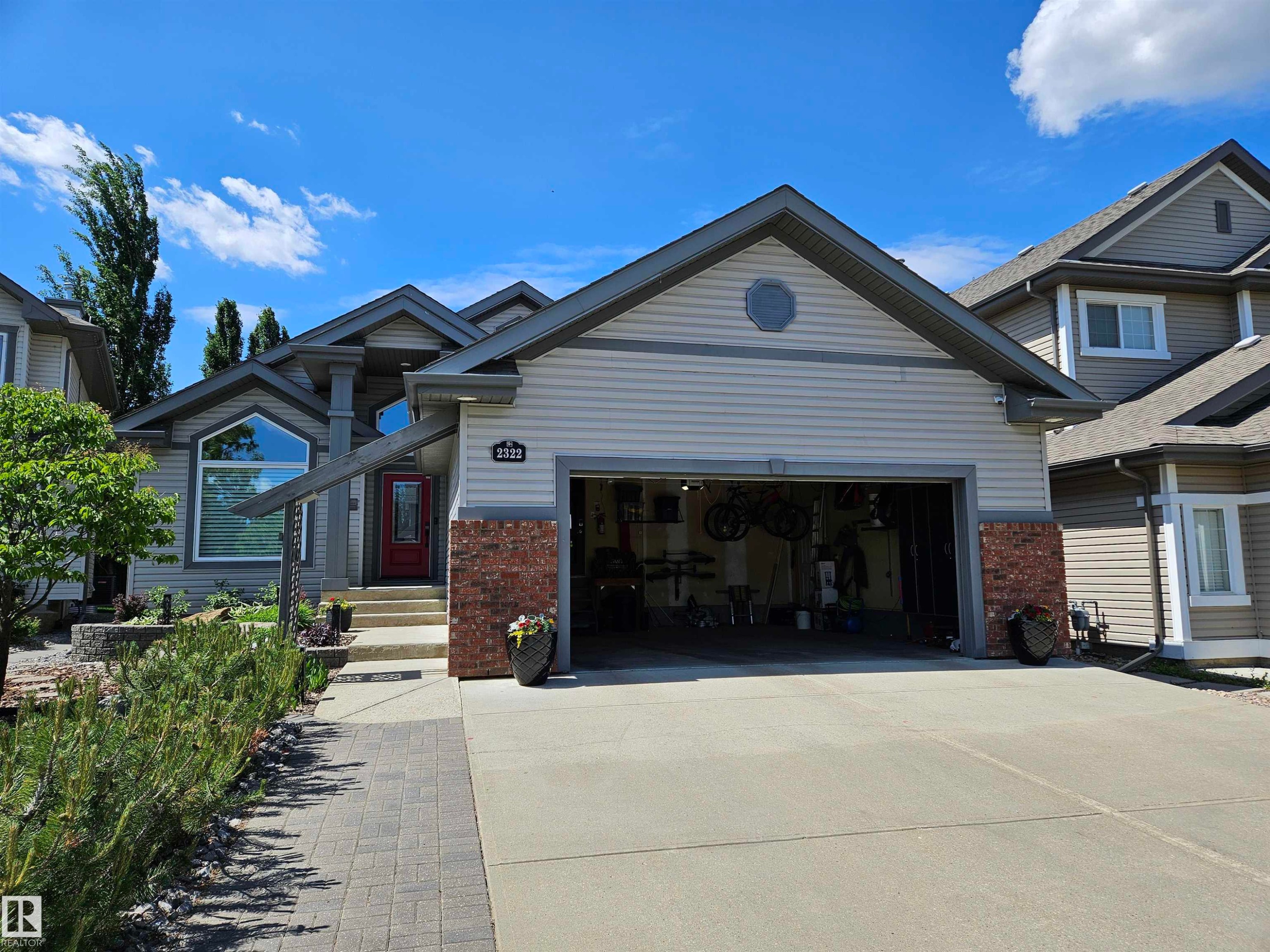 Modern exterior featuring light-colored siding, contrasting gray trim, and brick accents - 2322 Rutherford Way, Edmonton, AB