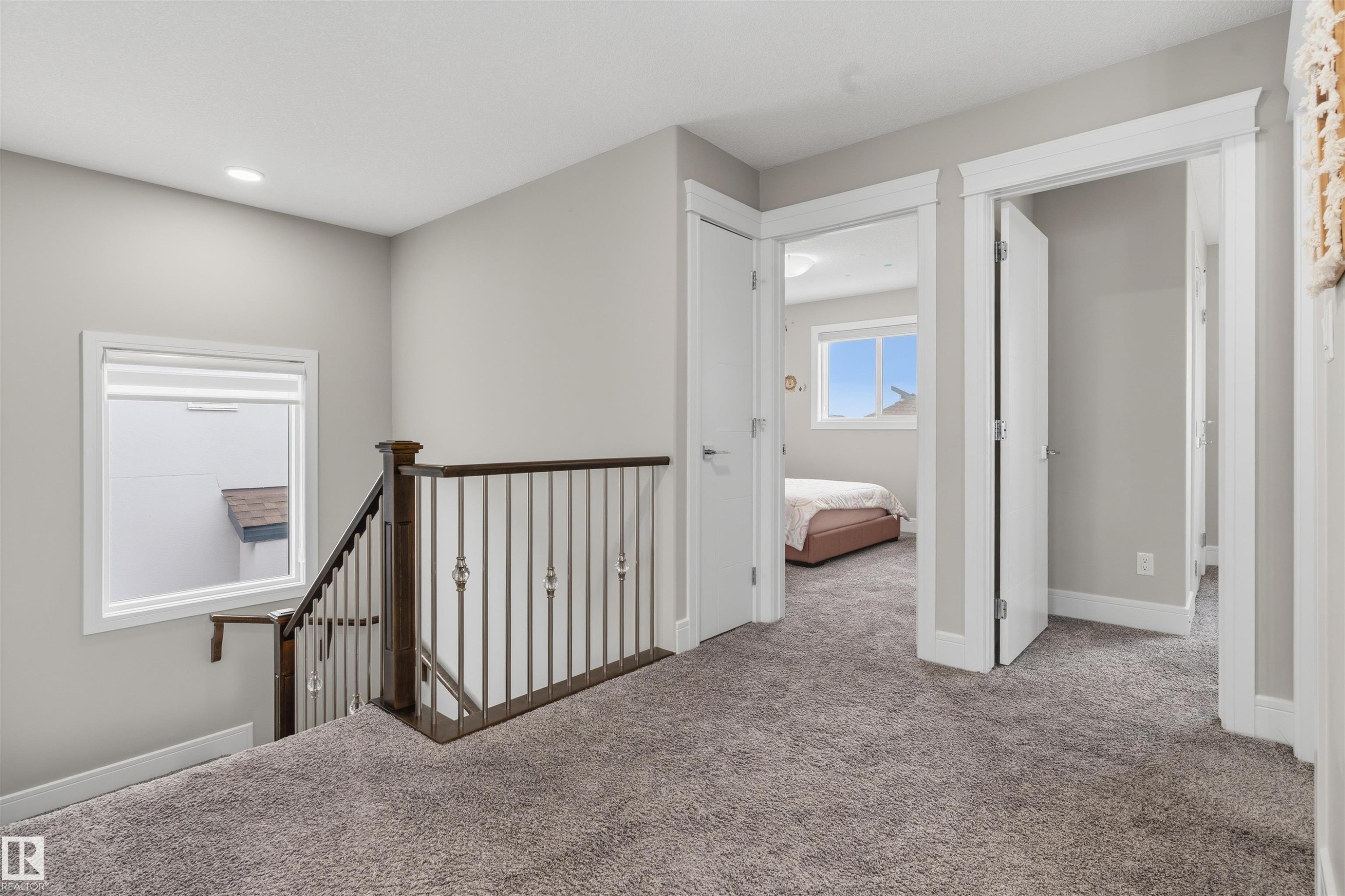 Upper-level landing featuring plush gray carpeting, white trim, and light gray wall paint - 3312 11 Avenue, Edmonton, AB