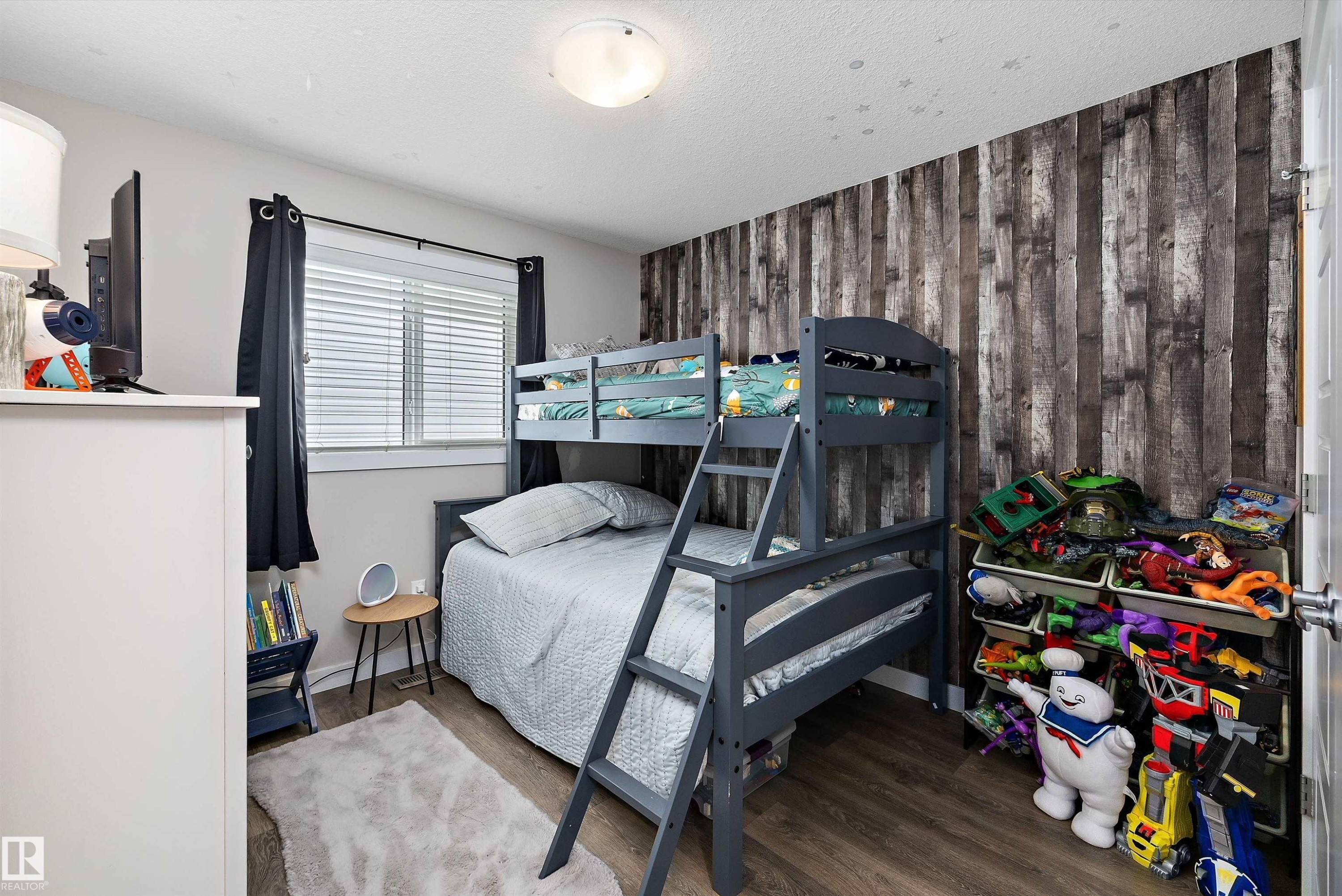 Interior room featuring wood-finish flooring and a distinctive wood panel accent wall - 363 Cy Becker Boulevard, Edmonton, AB - Indoor Photo Showing Bedroom