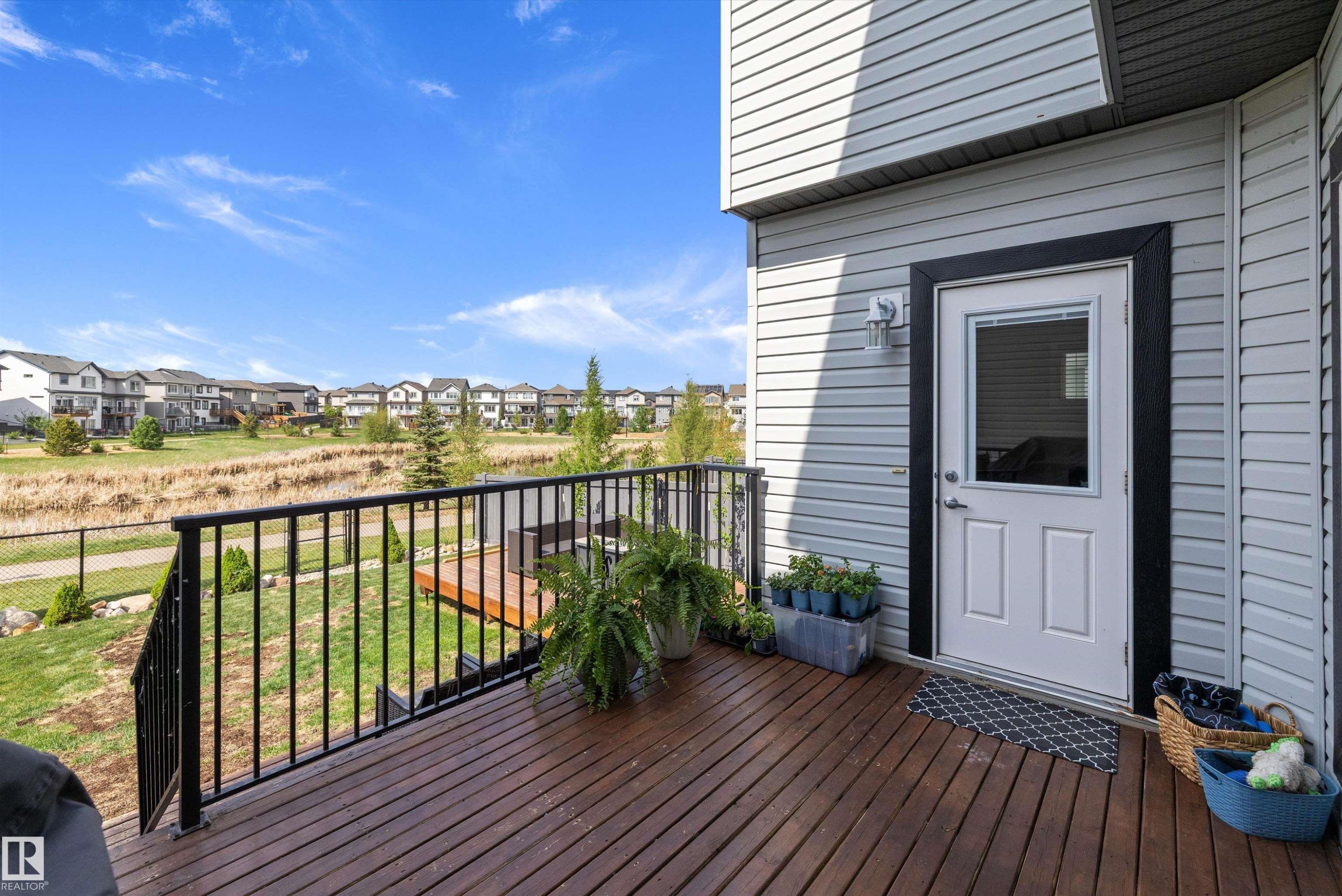 Deck with wood-finish flooring and black metal railings - 363 Cy Becker Boulevard, Edmonton, AB - Outdoor With Deck Patio Veranda With Exterior