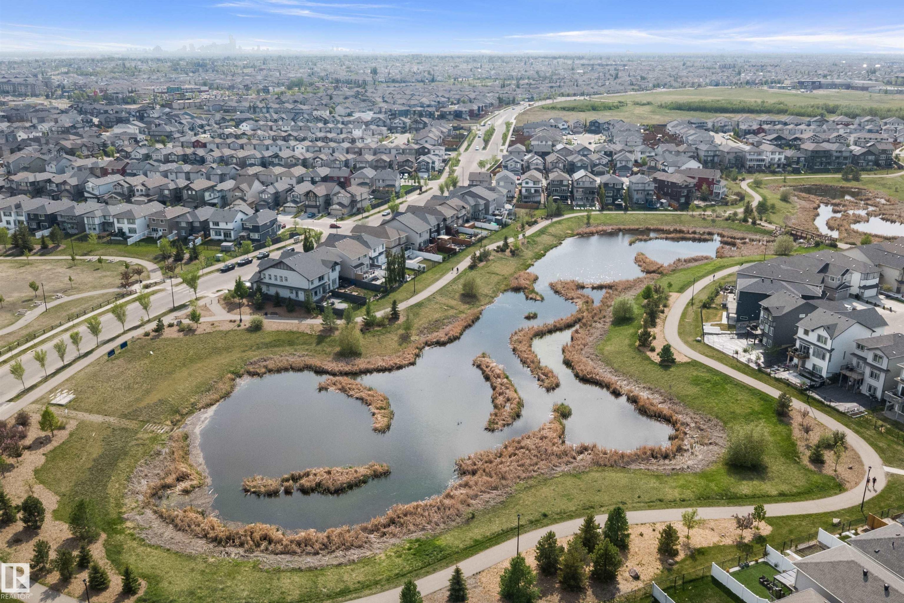 Aerial perspective showcasing a residential development with a central pond and surrounding green spaces - 363 Cy Becker Boulevard, Edmonton, AB - Outdoor With View