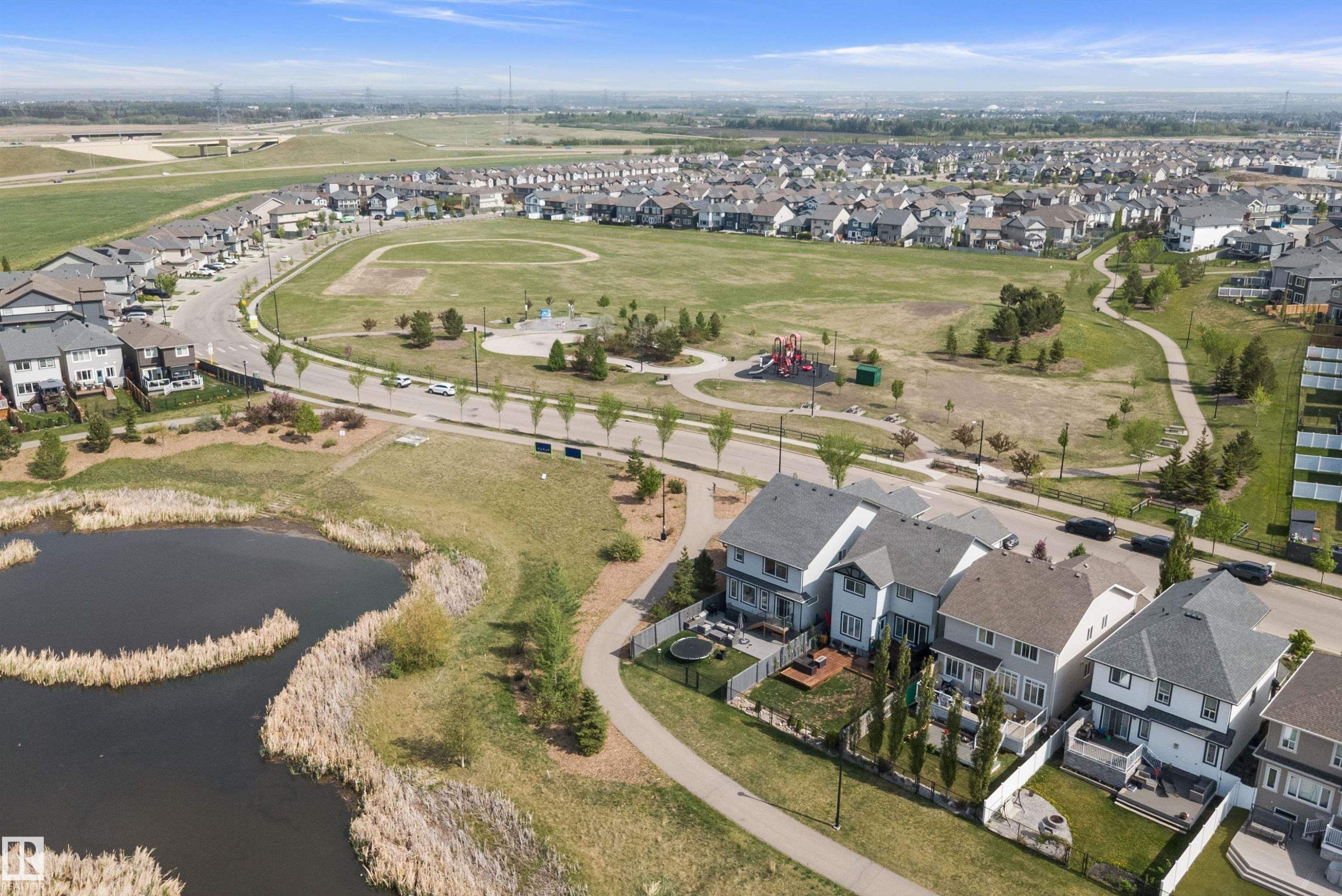 Aerial perspective showcasing residential properties bordering a community park and pond - 363 Cy Becker Boulevard, Edmonton, AB - Outdoor With View