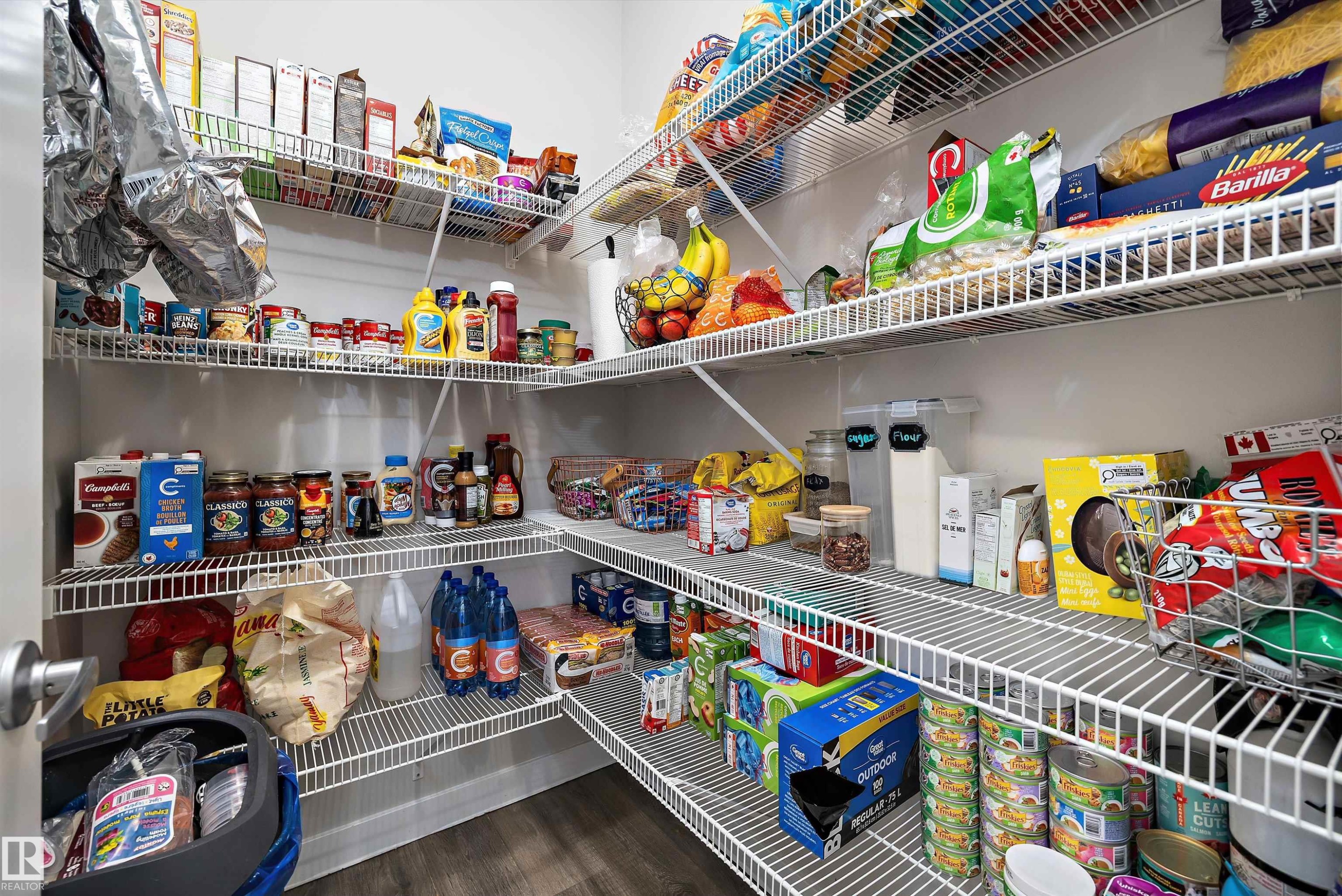 Walk-in pantry featuring white wire shelving, ample storage, and wood-finish flooring - 363 Cy Becker Boulevard, Edmonton, AB - Indoor With Storage