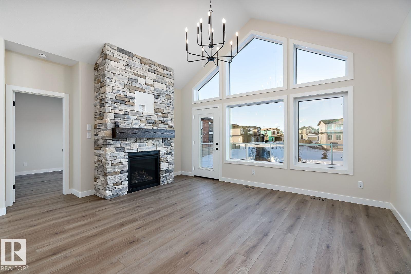 Stone-clad fireplace with a wood mantel - 110 Lilac Close, Leduc, AB