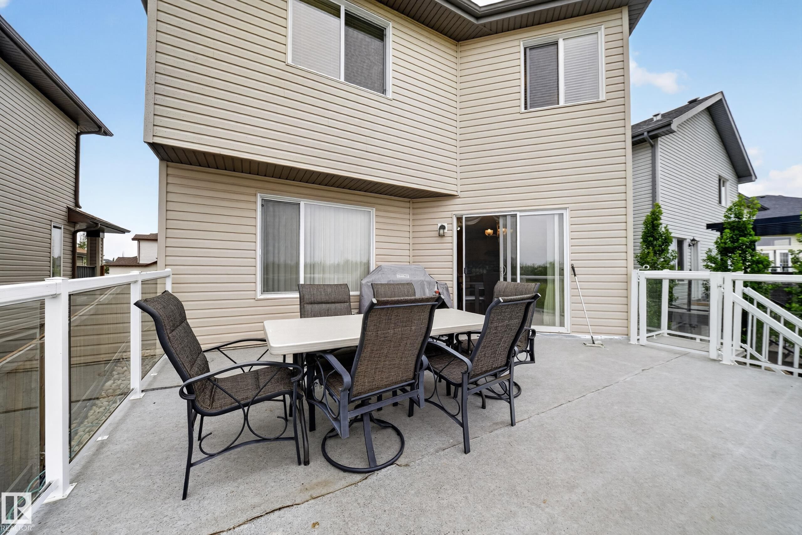 Expansive concrete deck featuring a modern glass railing system, providing outdoor living space - 2518 33A Avenue, Edmonton, AB