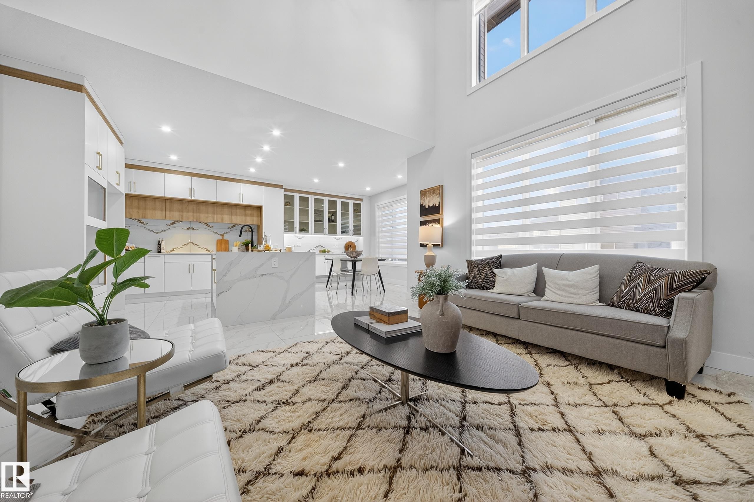 Open-concept living space with a two-story ceiling and large windows - 372 Creekside Green, Leduc, AB