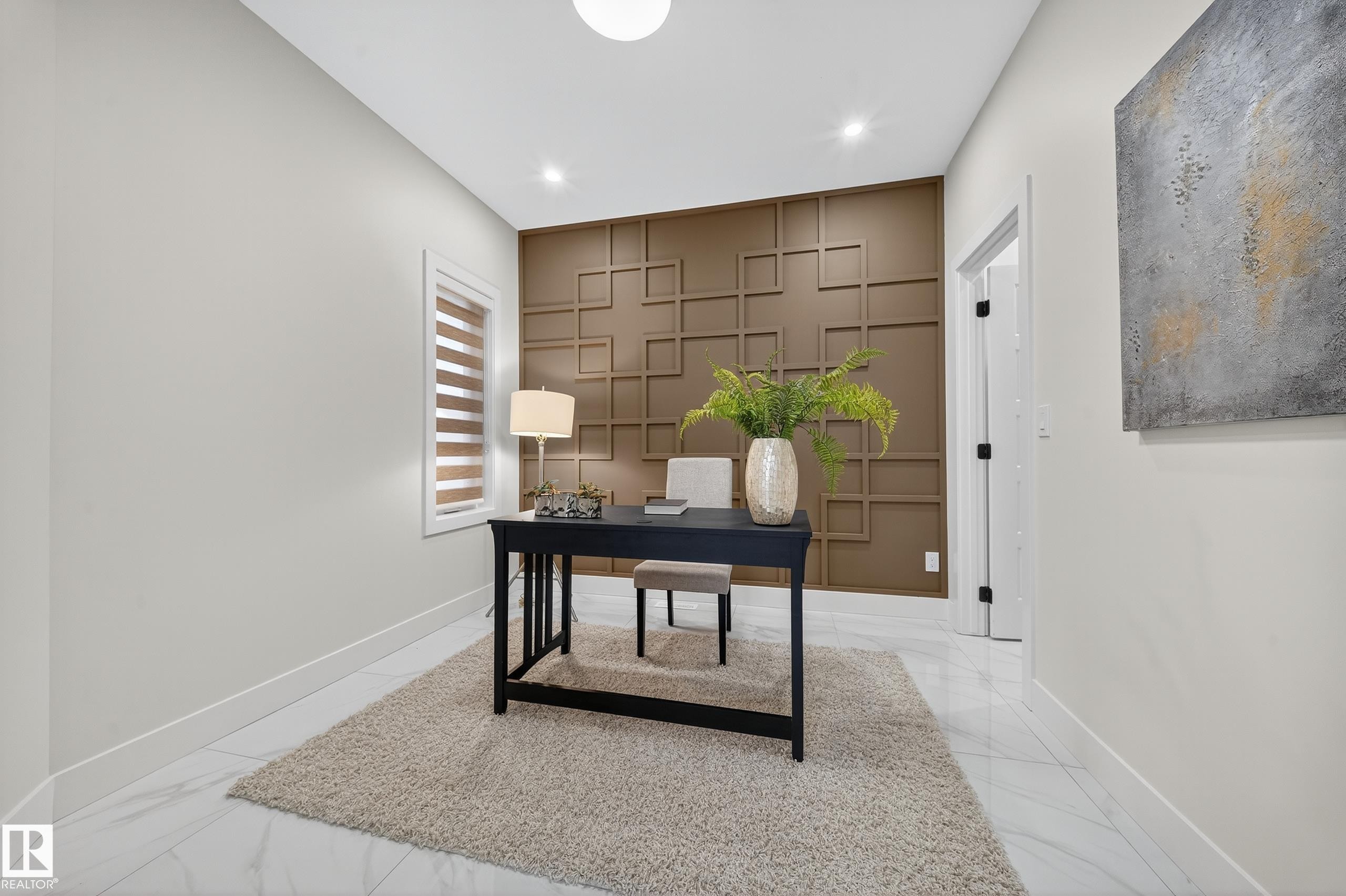 Home office space featuring a geometric accent wall, recessed lighting, and large format tile flooring - 372 Creekside Green, Leduc, AB