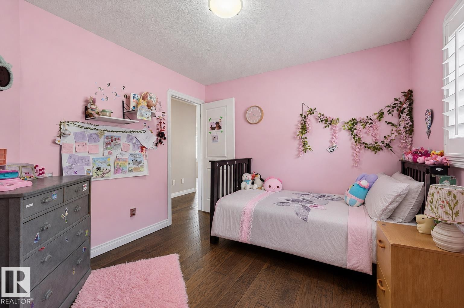 Bedroom featuring wood-finish flooring, a contemporary ceiling light fixture, and white window shutters - 21928 97 Avenue Nw, Edmonton, AB - Indoor Photo Showing Bedroom