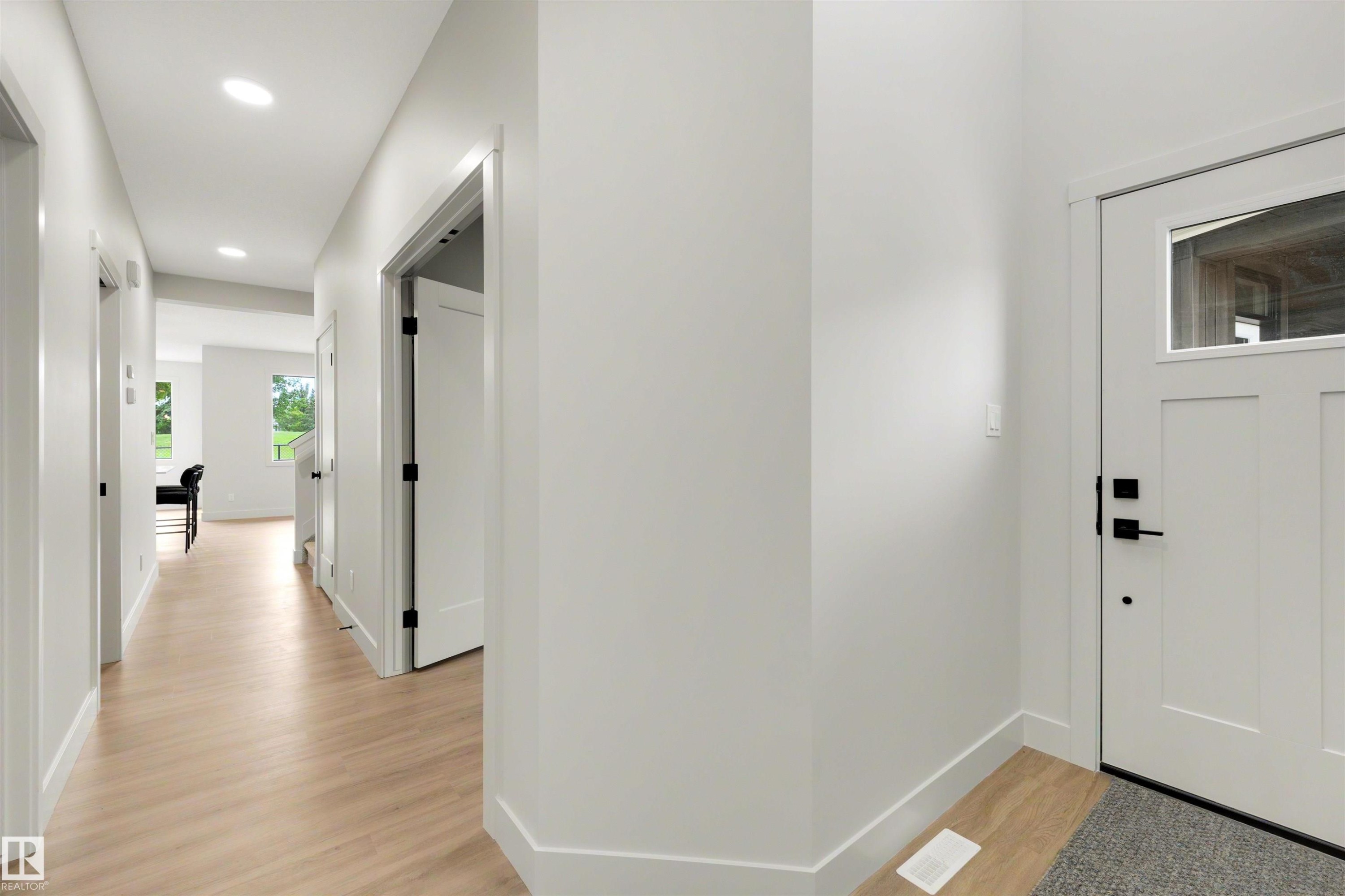 Light wood-finish flooring extending through the hallway - 24 Grayson Green, Stony Plain, AB