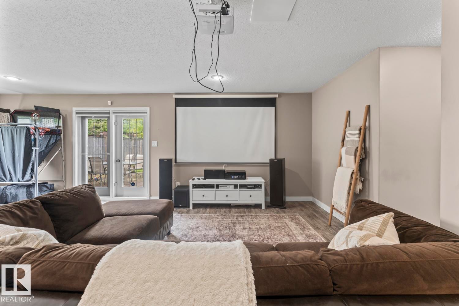 Media room featuring a ceiling-mounted projector, retractable screen, and recessed lighting - 2602 Delta Road, Cold Lake, AB