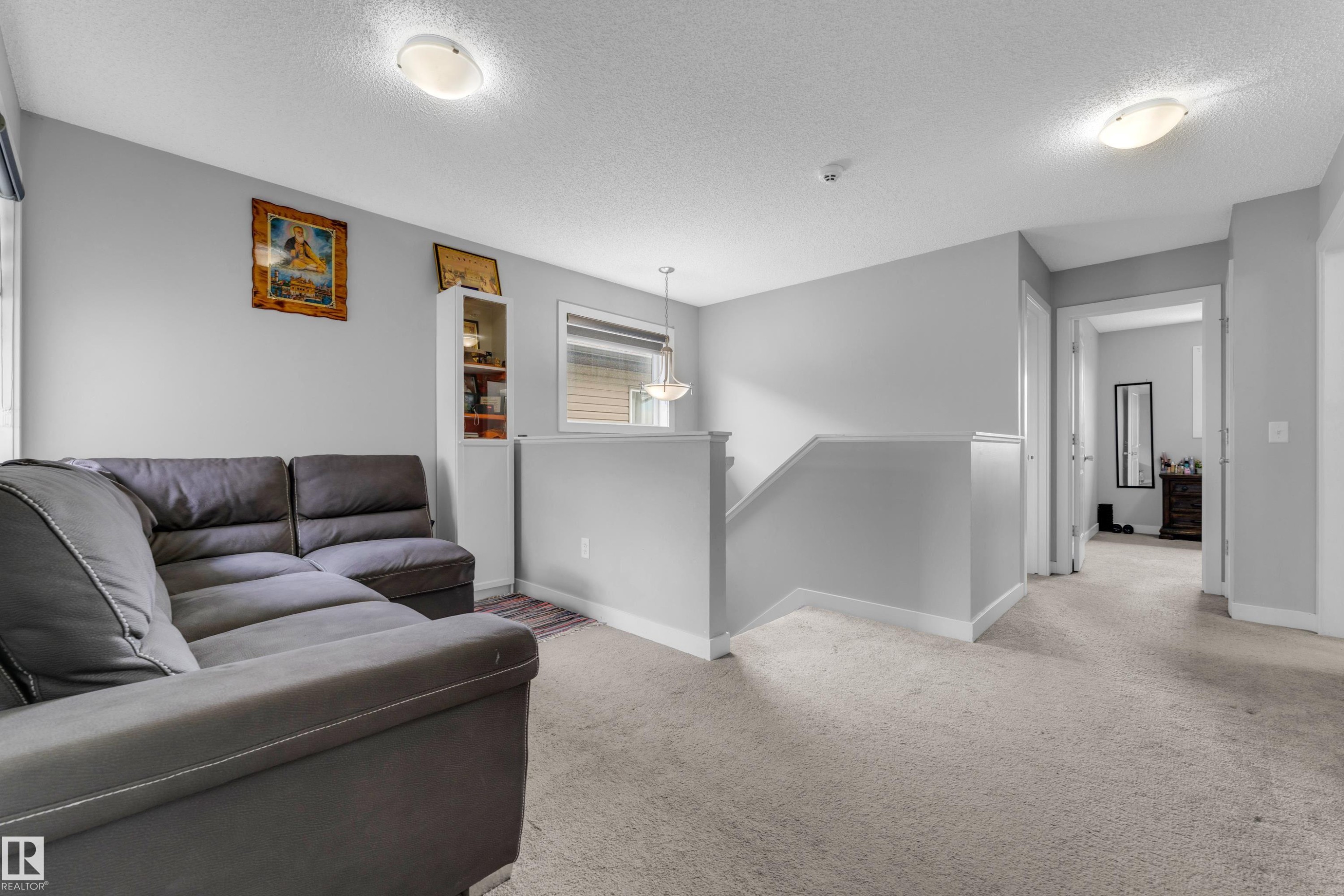 Carpeted bonus room with neutral wall tones and a built-in shelving unit - 1750 27 Street, Edmonton, AB