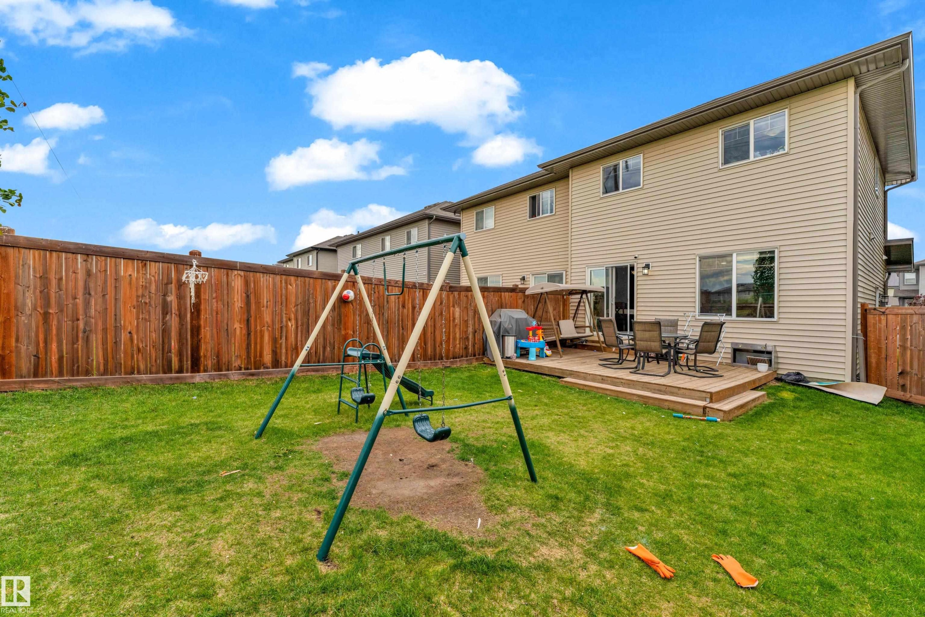 Spacious backyard featuring a multi-level wood deck, wood privacy fencing, and a manicured lawn - 1750 27 Street, Edmonton, AB