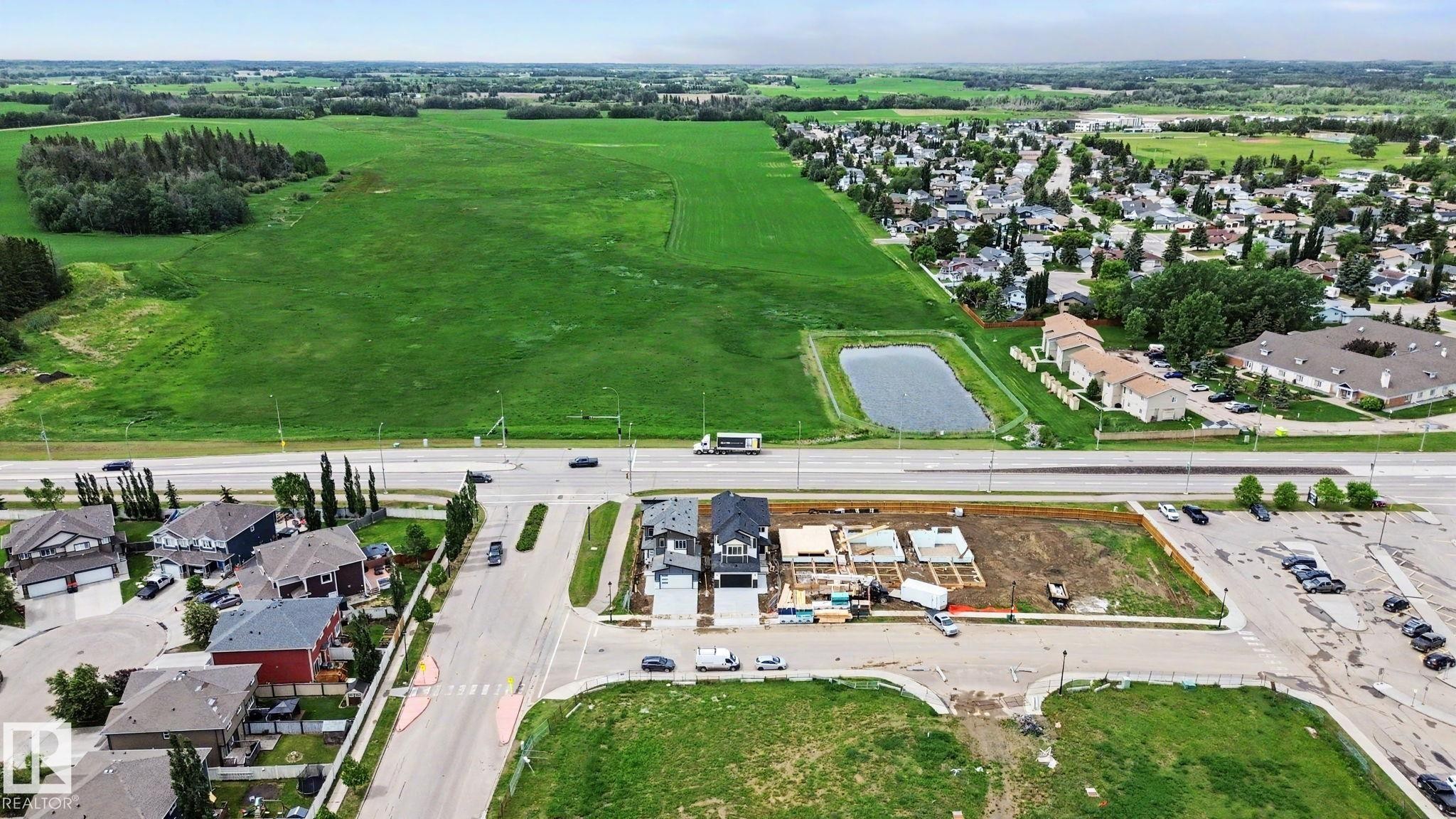 Aerial perspective showcasing a developing residential area with new construction sites - 4 Willow Heights Drive, Stony Plain, AB