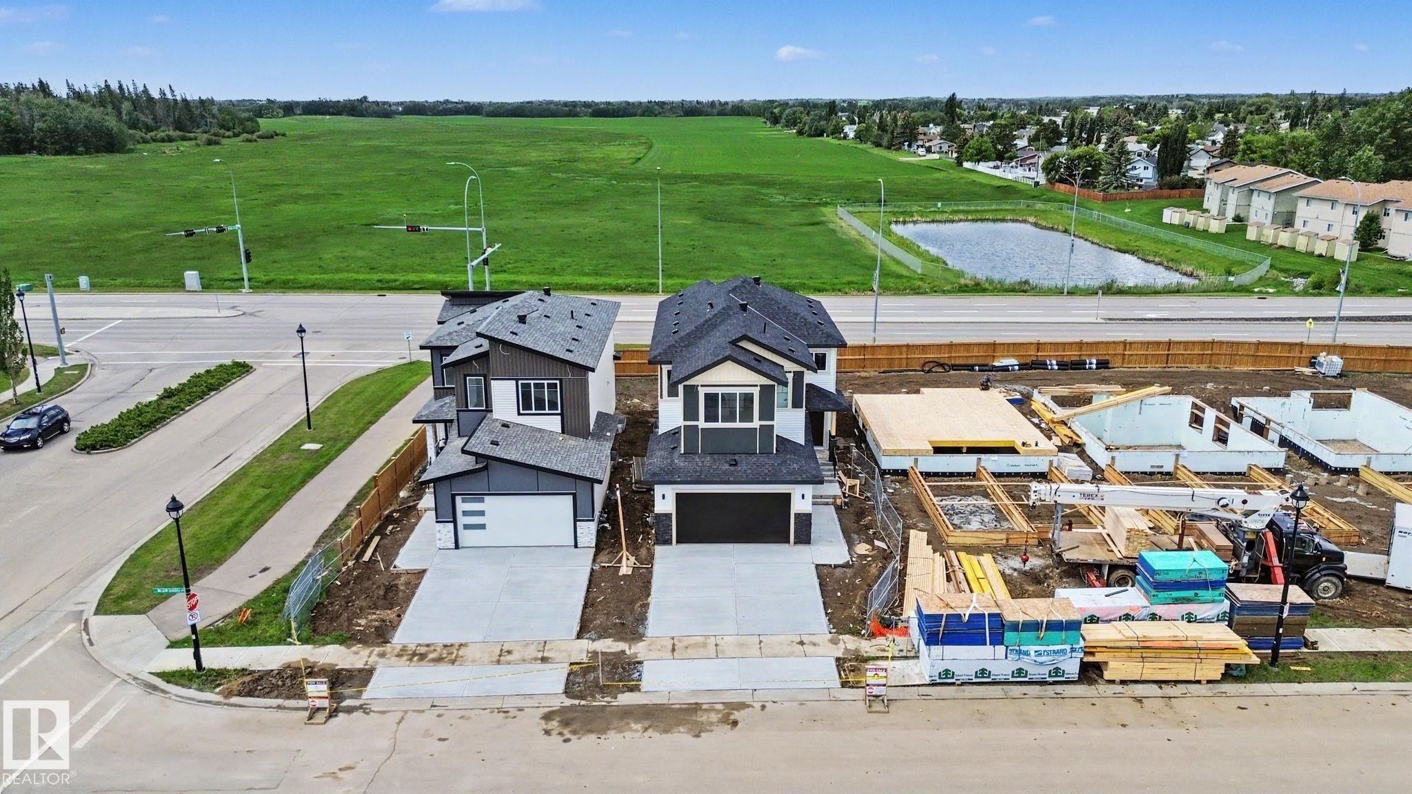 Newly constructed residences featuring modern architecture, attached garages, and concrete driveways - 4 Willow Heights Drive, Stony Plain, AB