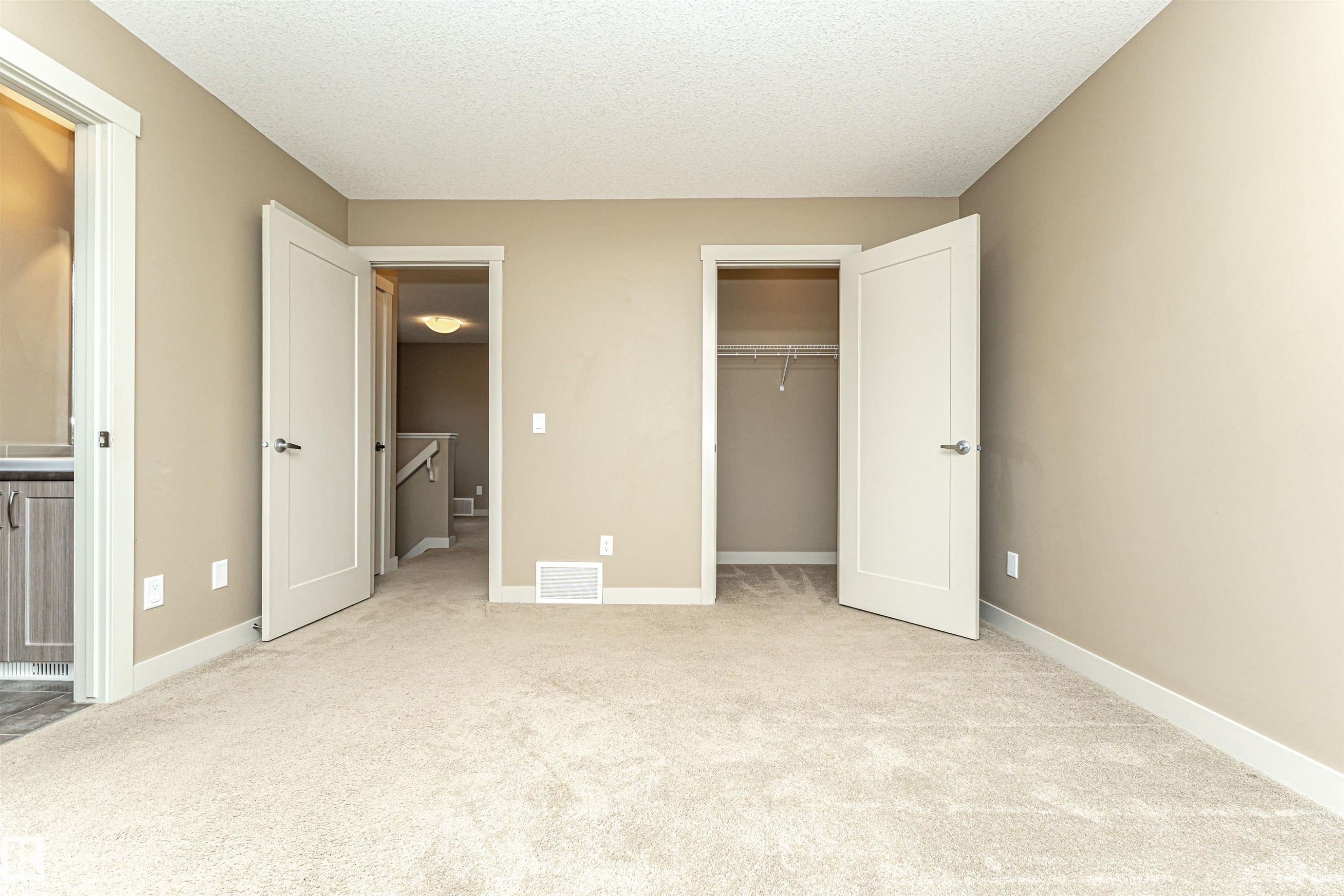 Neutral-toned room featuring light beige carpeting, white baseboards, and a neutral wall color - 2397 Glenridding Boulevard, Edmonton, AB