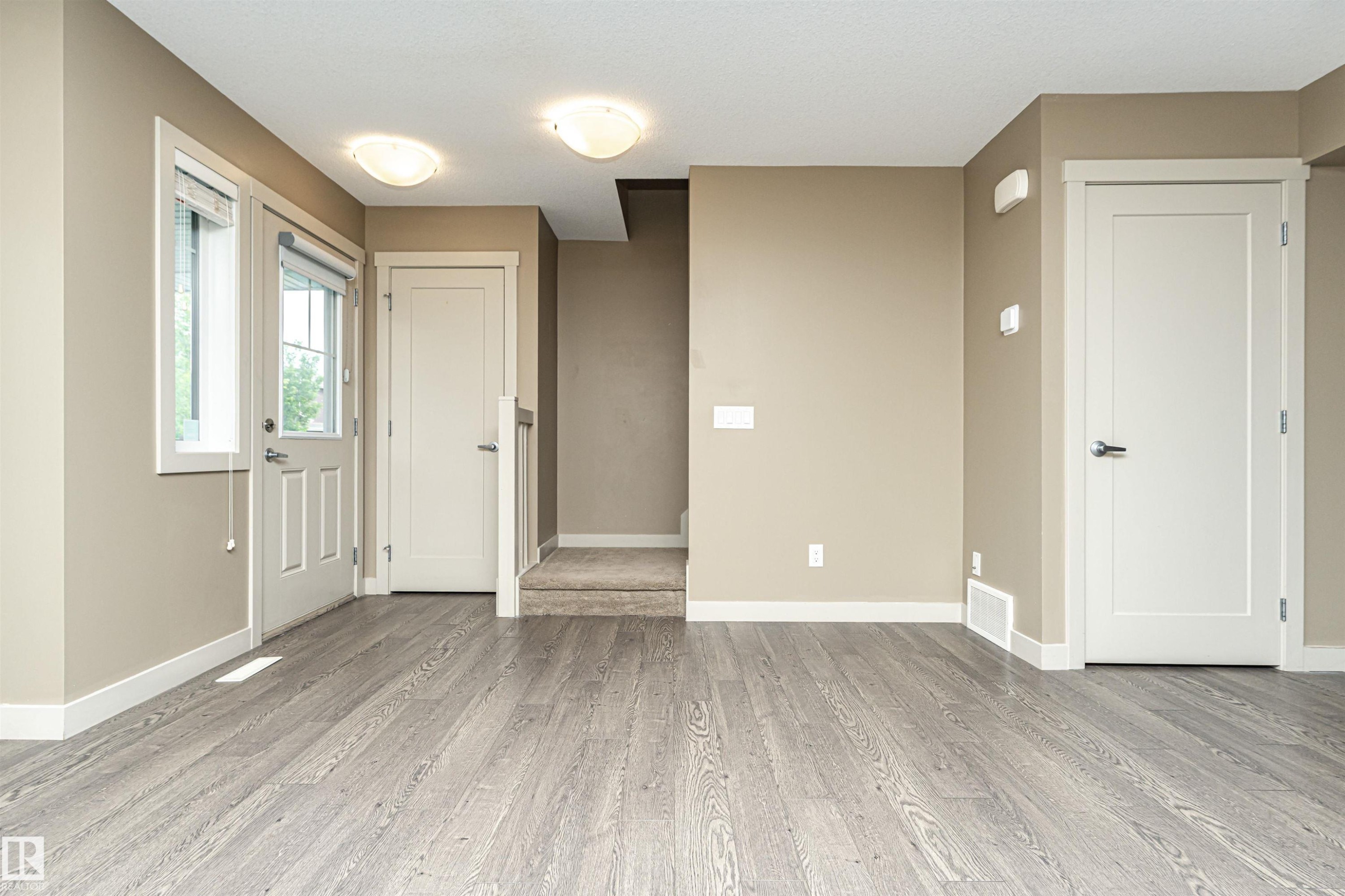 Light wood-finish flooring throughout the main level - 2397 Glenridding Boulevard, Edmonton, AB