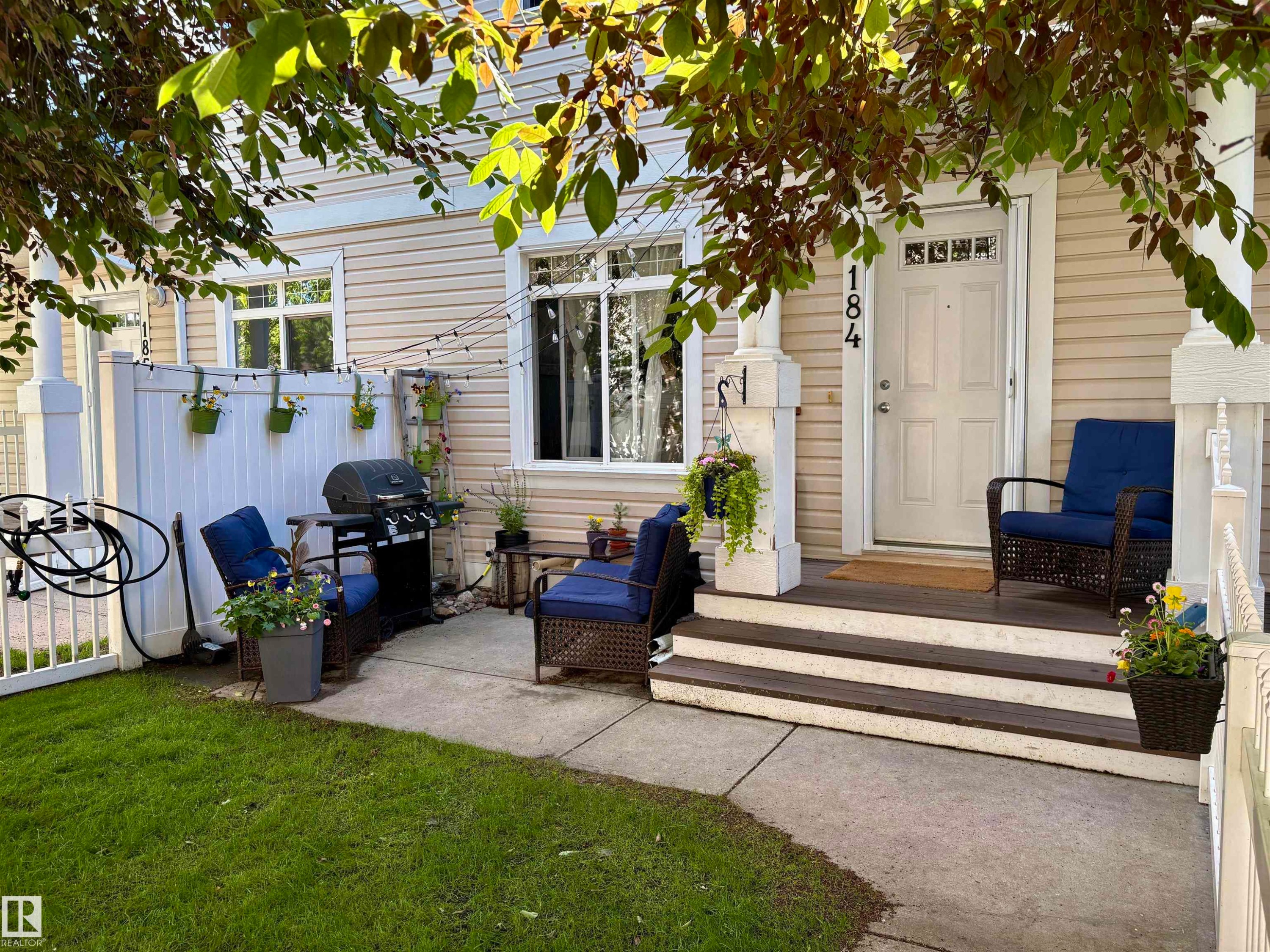 Front facade with horizontal siding and a white entry door featuring decorative glass - 184 1804 70 Street, Edmonton, AB
