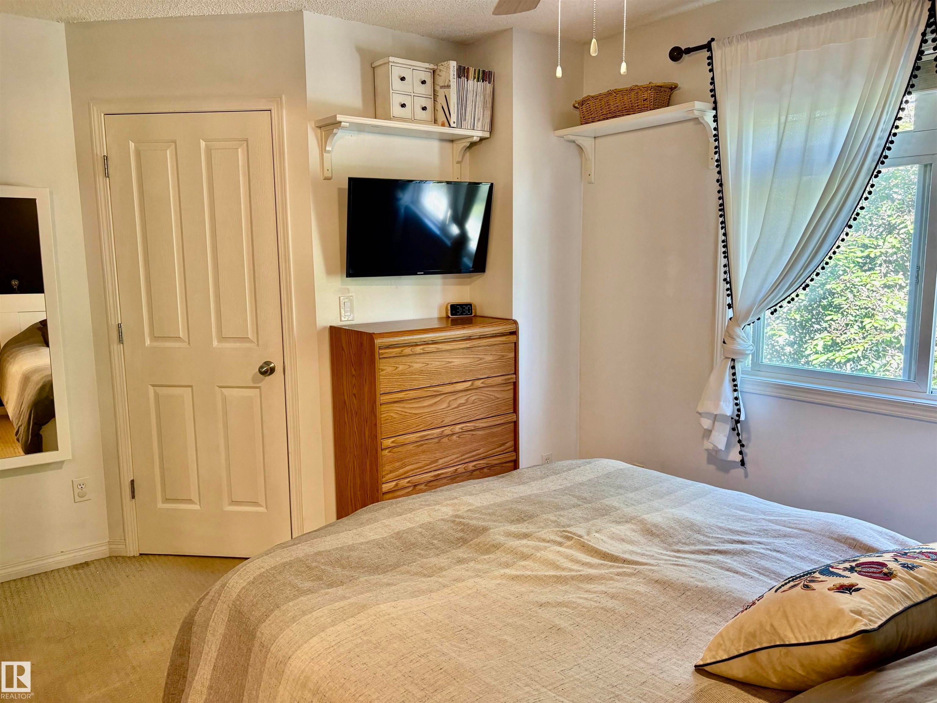 Bright bedroom space featuring a window with exterior views - 184 1804 70 Street, Edmonton, AB