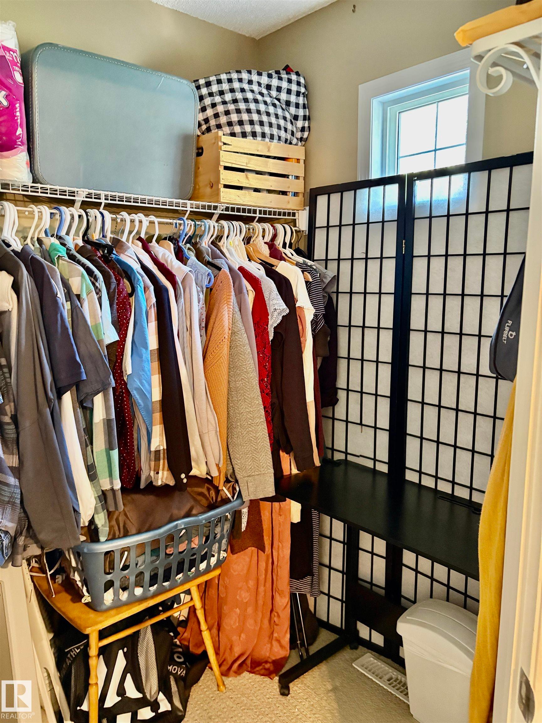 Closet space featuring wire shelving, a window providing natural light, and neutral-toned walls - 184 1804 70 Street, Edmonton, AB