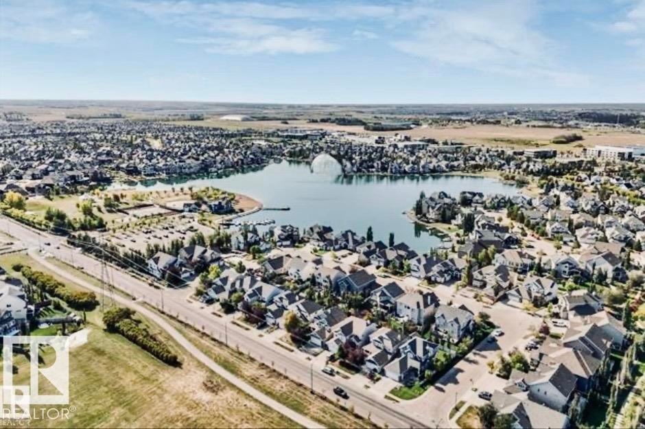 Expansive aerial showcasing a residential community surrounding a central lake - 184 1804 70 Street, Edmonton, AB