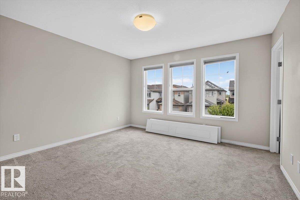 Neutral tone wall finish, plush carpeting, and a flush mount ceiling fixture - 2144 51 Street, Edmonton, AB
