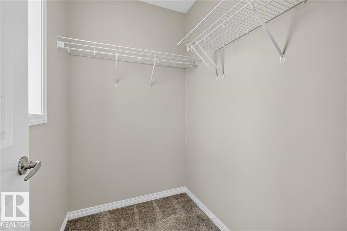 Dedicated closet space featuring wire shelving systems, neutral wall tones, and carpet flooring - 2144 51 Street, Edmonton, AB