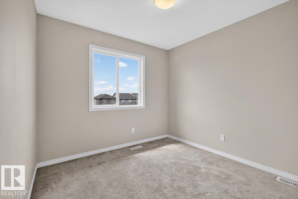 Neutral tone wall paint with white trim, gray carpet flooring, and a double-pane window - 2144 51 Street, Edmonton, AB