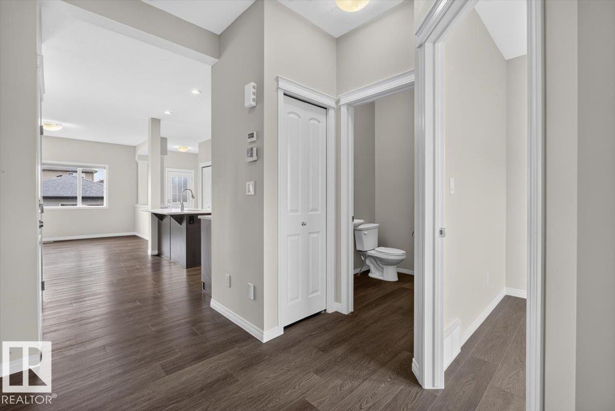 Open concept layout featuring wood-finish flooring, white baseboards, and neutral wall tones - 2144 51 Street, Edmonton, AB