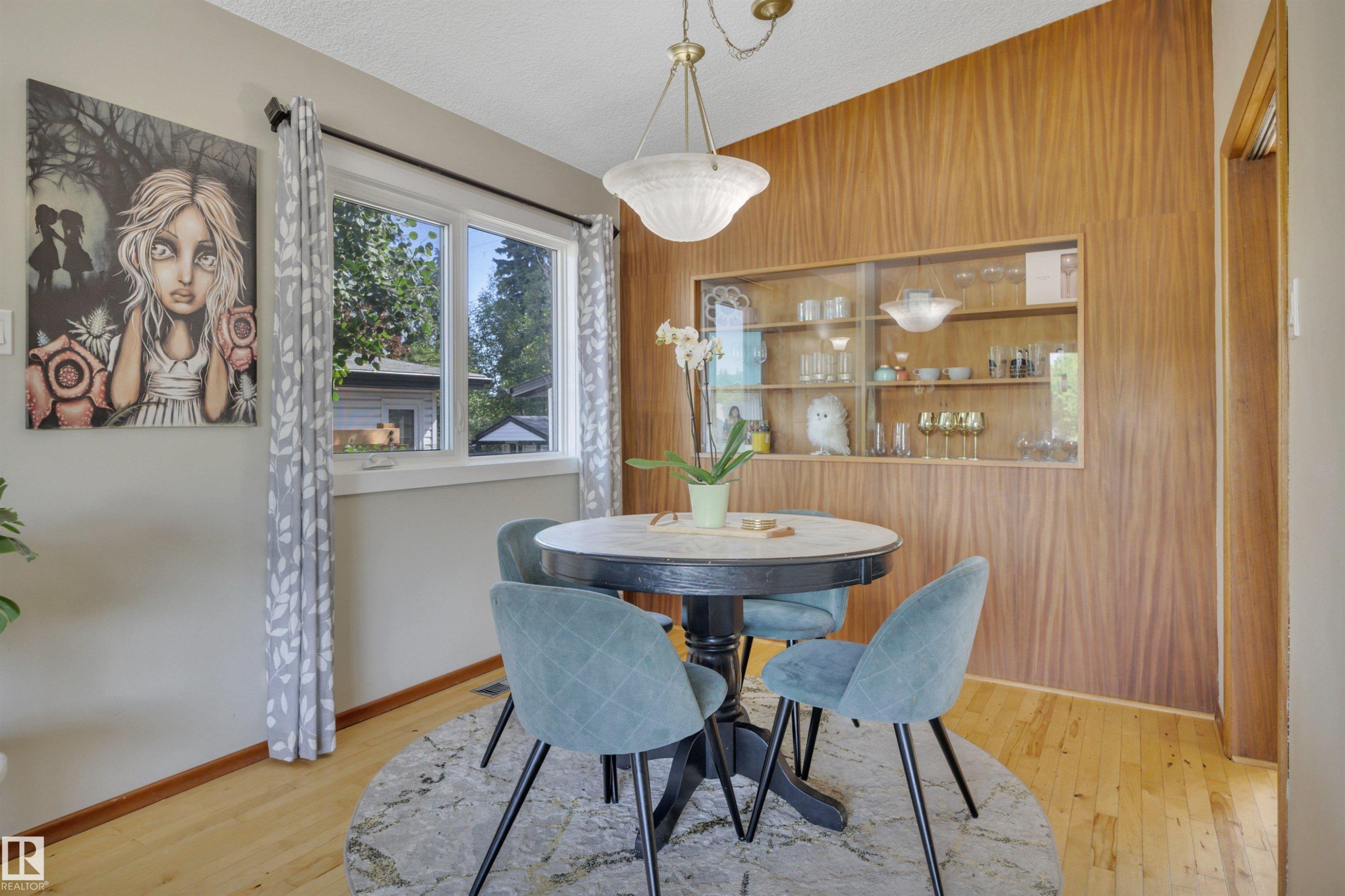 Dining space featuring wood-finish wall paneling with an integrated display cabinet - 9835 74 Street, Edmonton, AB