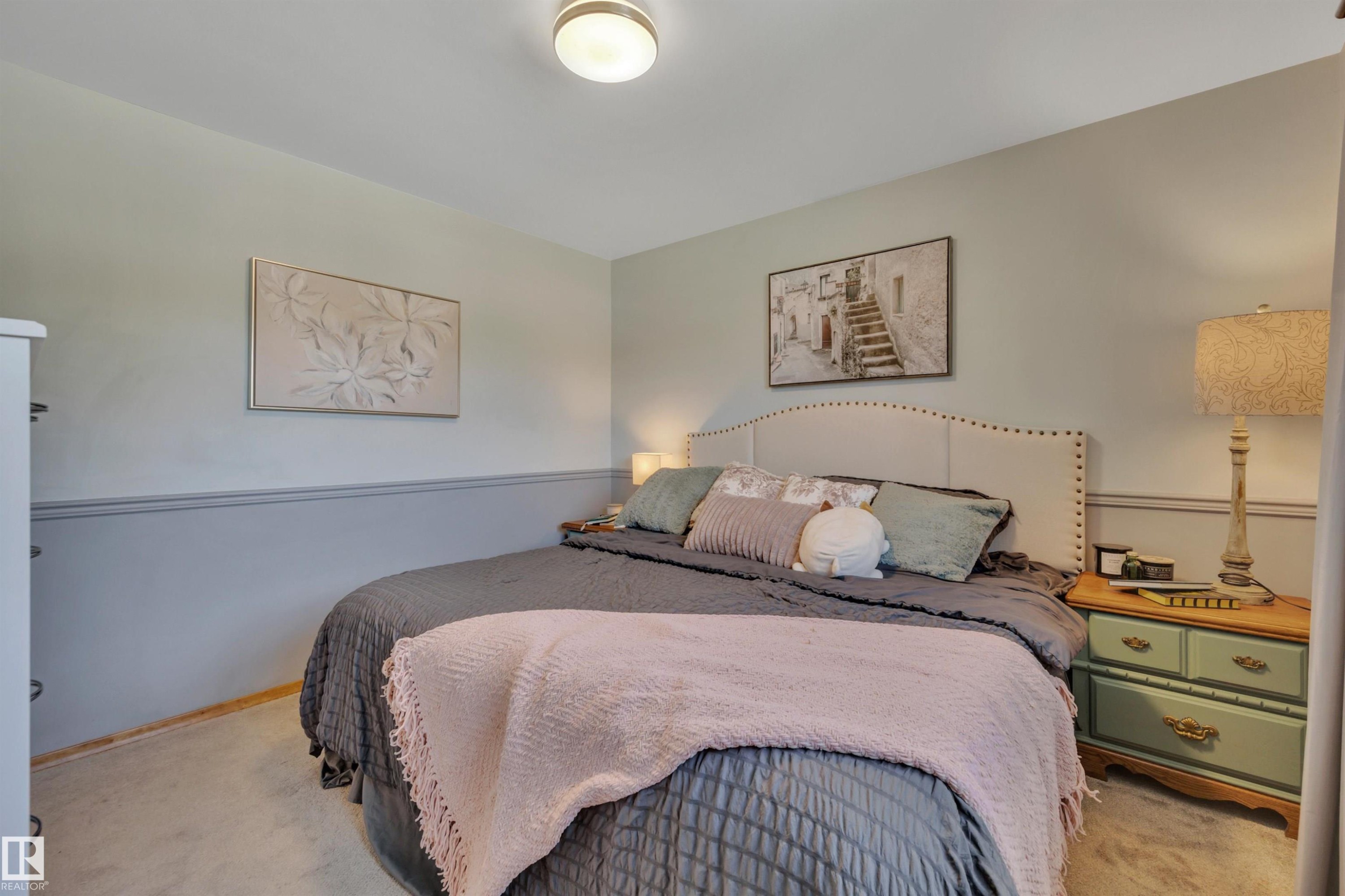 Wall-to-wall carpeting complements a two-tone wall treatment with a chair rail - 9835 74 Street, Edmonton, AB