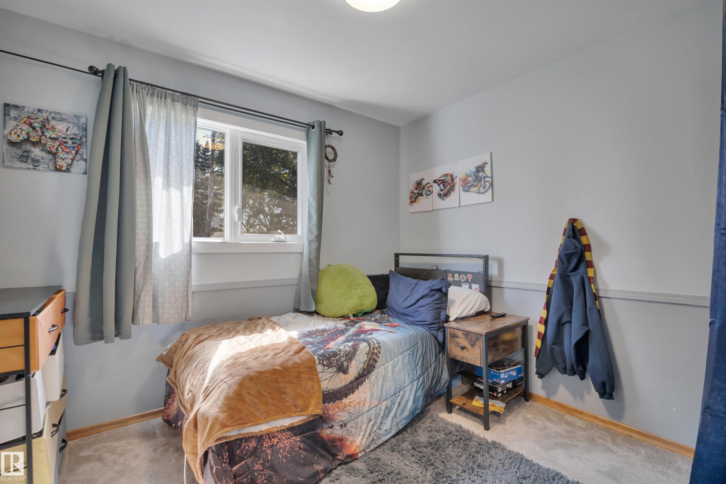 Bedroom featuring light gray walls, white trim, and a double-pane window - 9835 74 Street, Edmonton, AB