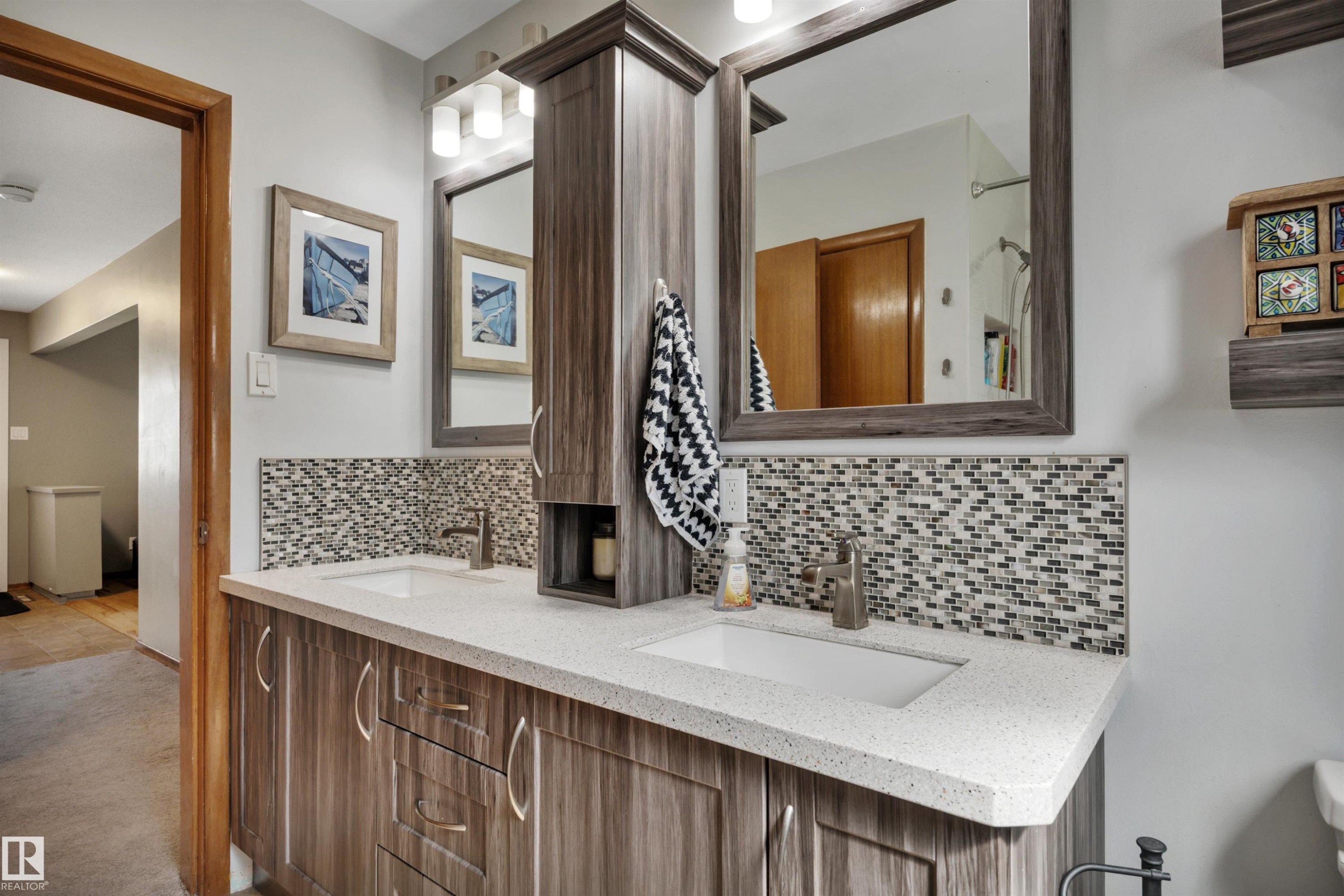 Double vanity with a light-toned countertop, dual rectangular undermount sinks, and a mosaic tile backsplash - 9835 74 Street, Edmonton, AB