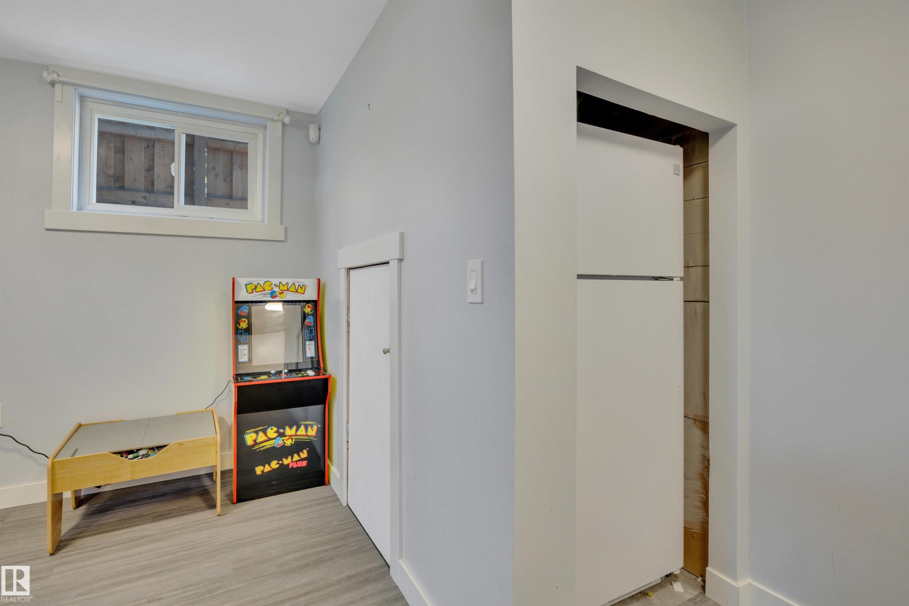 White-framed window with wood-look flooring, light gray walls, and white trim - 9835 74 Street, Edmonton, AB