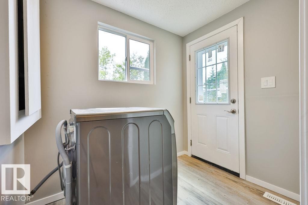 Utility area featuring light wood-finish flooring and neutral wall tones - 11241 88 Street, Edmonton, AB