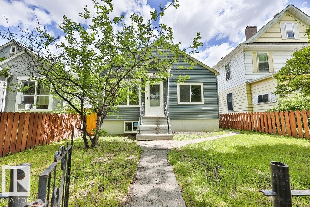 Single-story residence featuring horizontal siding, a covered front entry, and a concrete walkway - 11241 88 Street, Edmonton, AB