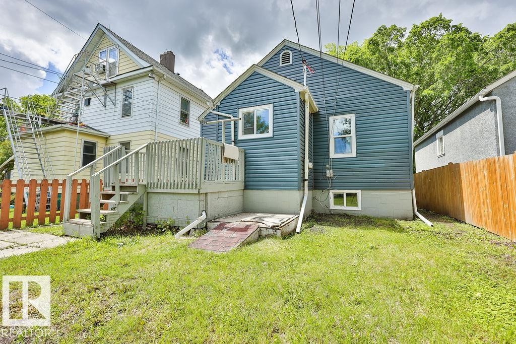 Rear exterior of the property featuring blue horizontal siding and white trim - 11241 88 Street, Edmonton, AB