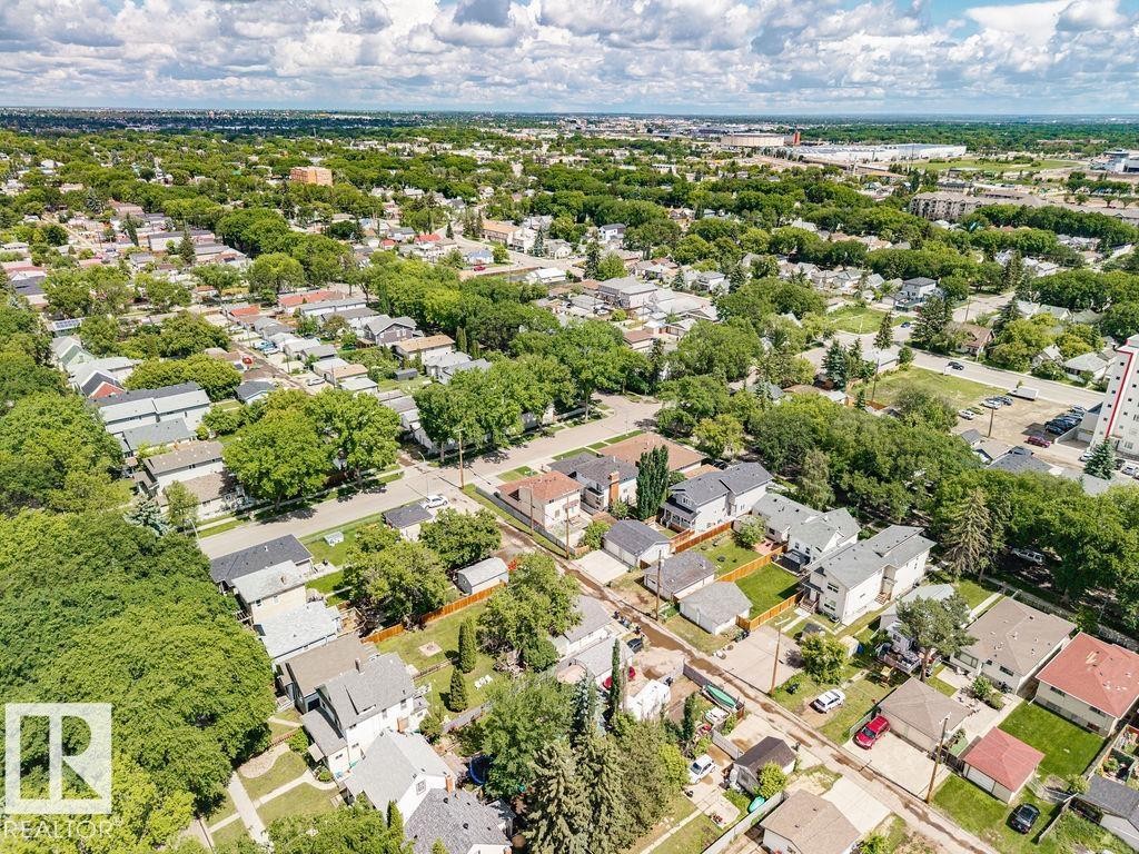 Residential neighborhood featuring mature tree-lined streets, a mix of single-family homes and multi-story structures, paved roads, and fenced yards - 11241 88 Street, Edmonton, AB