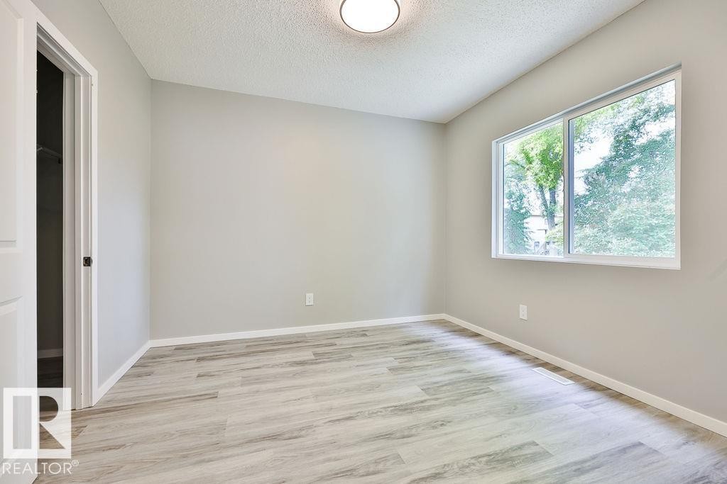 Room featuring wood-finish flooring and a single pane window - 11241 88 Street, Edmonton, AB