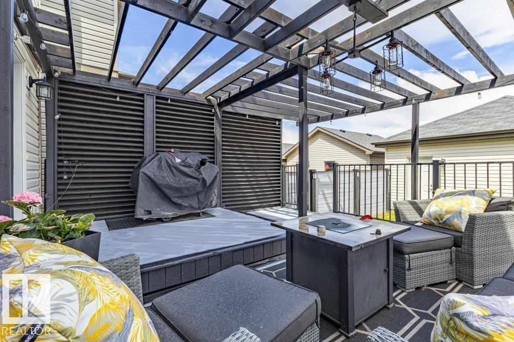 Expansive outdoor deck featuring a dark-stained wood pergola, privacy screens, and a multi-level composite decking surface - 17123 49 Street, Edmonton, AB
