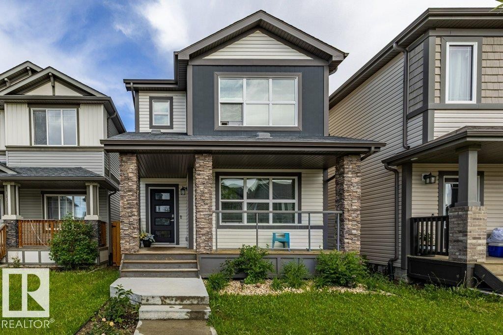 Contemporary facade featuring multi-tone siding and stone column accents - 17123 49 Street, Edmonton, AB