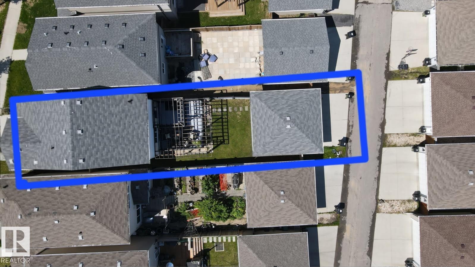 Two distinct buildings with gray shingled roofs and private driveways - 17123 49 Street, Edmonton, AB