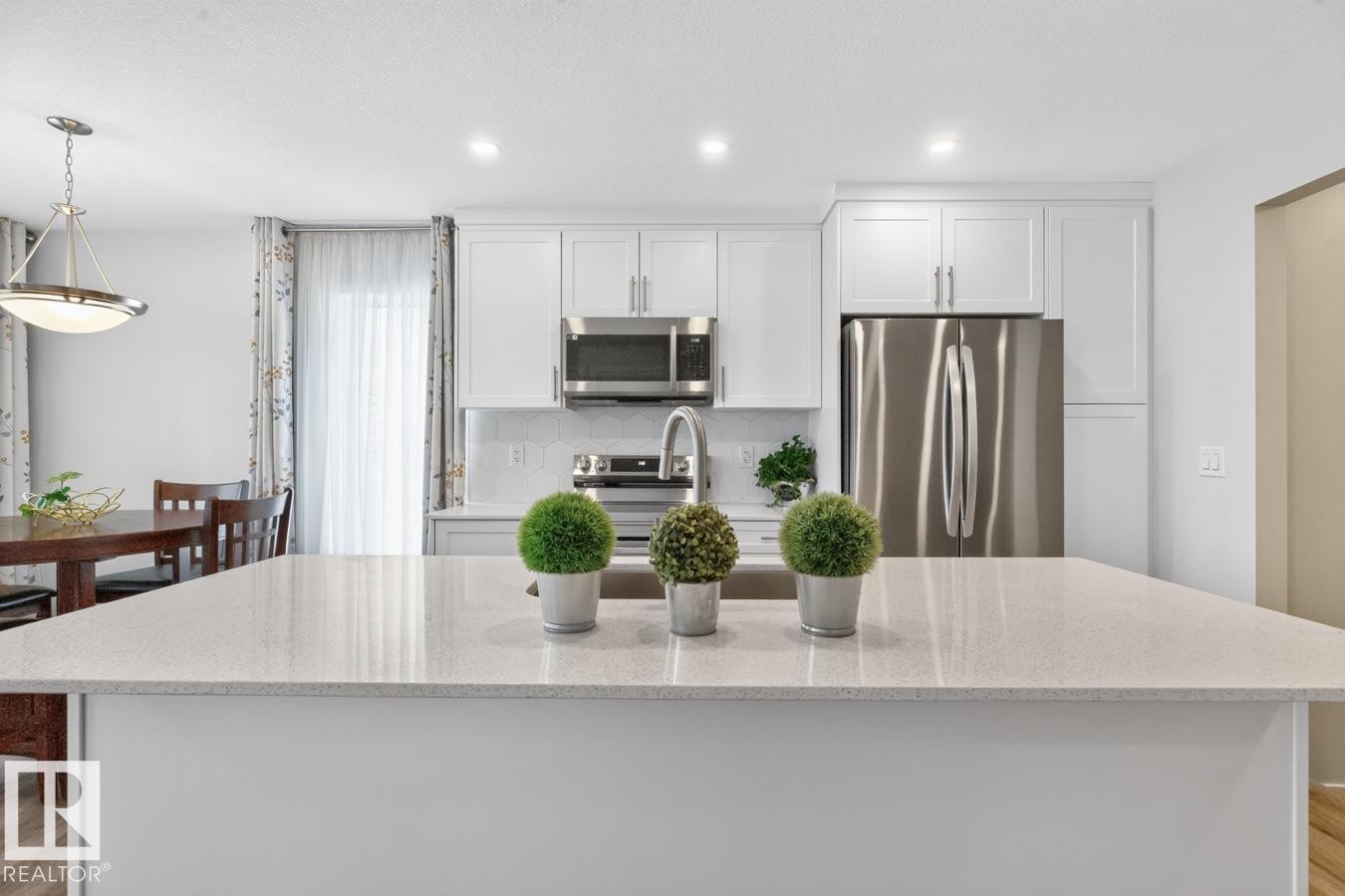 Kitchen island featuring a light-toned countertop - 1022 Hearthstone Boulevard, Sherwood Park, AB