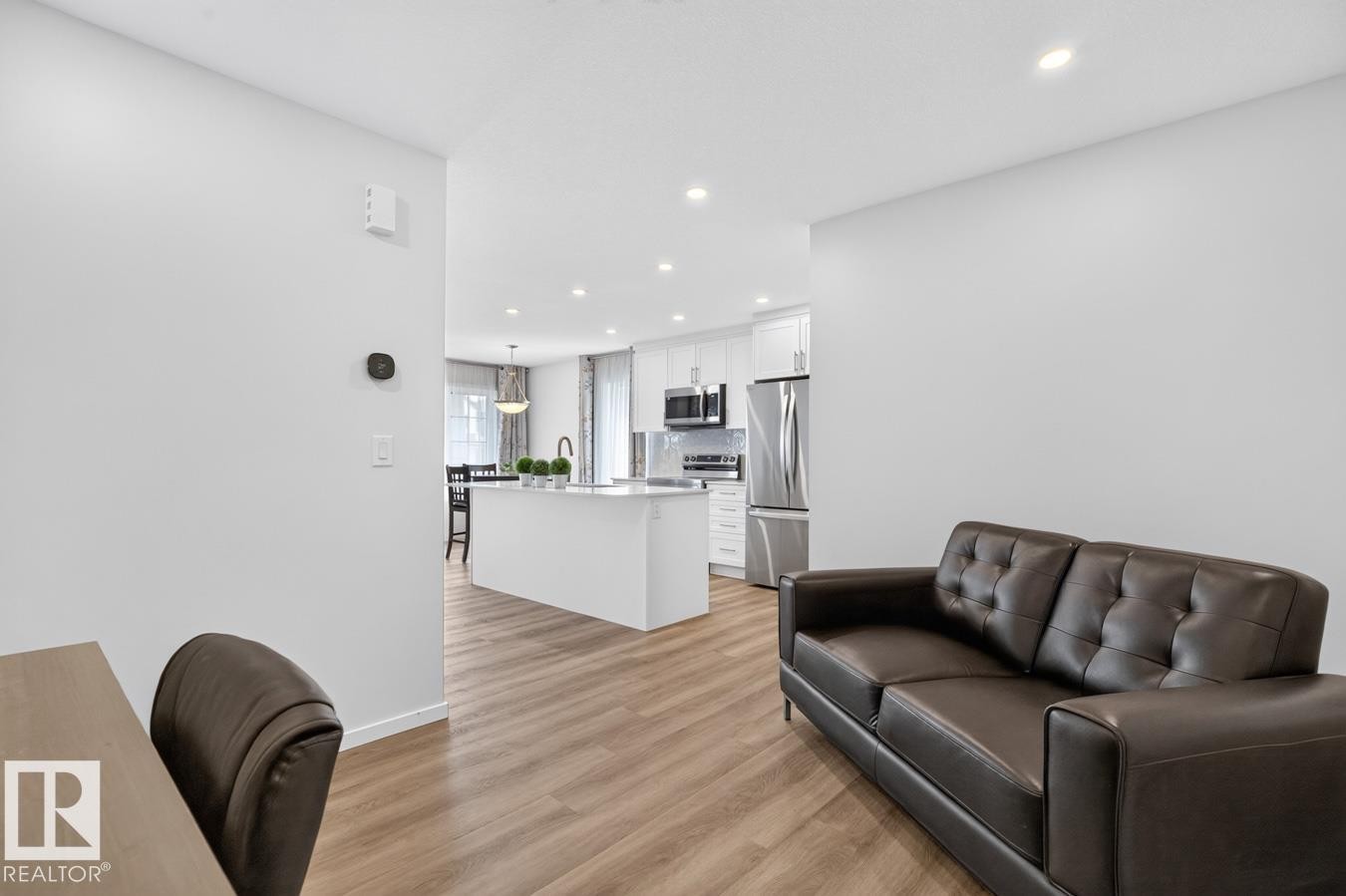 Open-concept living area with wood-finish flooring, recessed lighting, and a white color palette - 1022 Hearthstone Boulevard, Sherwood Park, AB