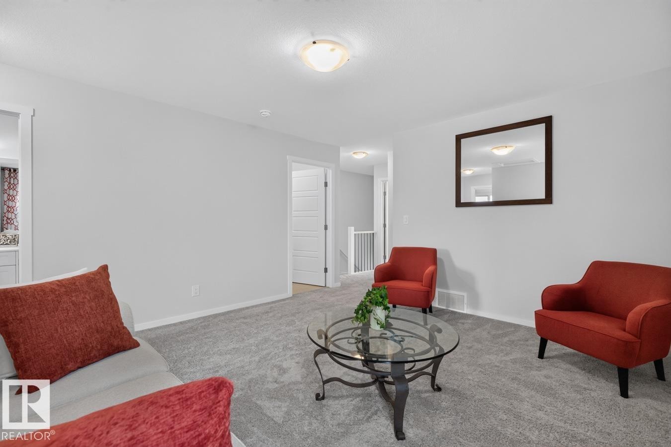 Carpeted living area featuring light gray walls, a white ceiling, and a flush-mount ceiling light - 1022 Hearthstone Boulevard, Sherwood Park, AB