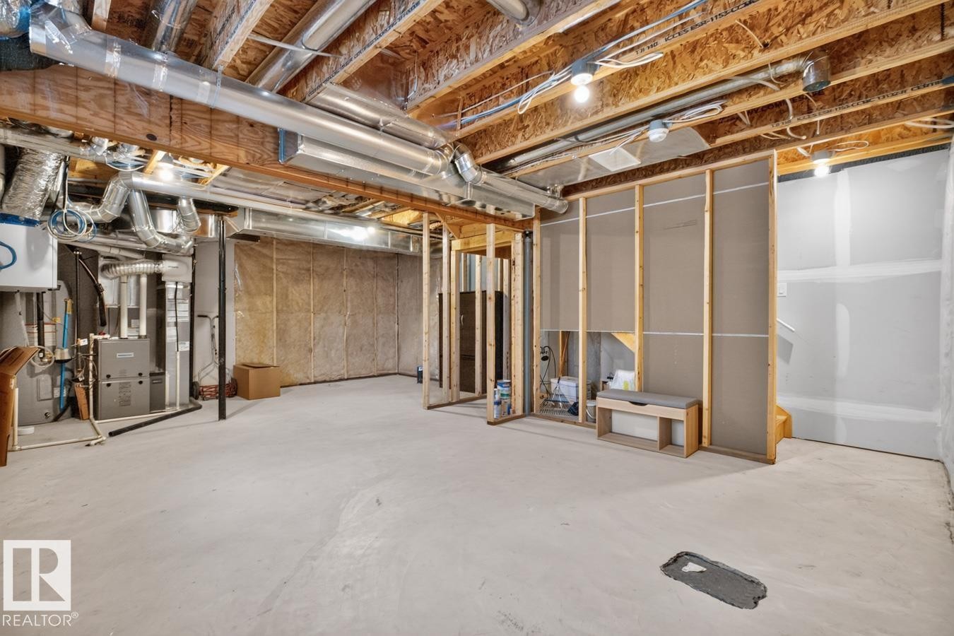 Unfinished lower level offering expansive open space, visible mechanical systems, exposed ceiling joists, framed partition walls, and concrete flooring - 1022 Hearthstone Boulevard, Sherwood Park, AB