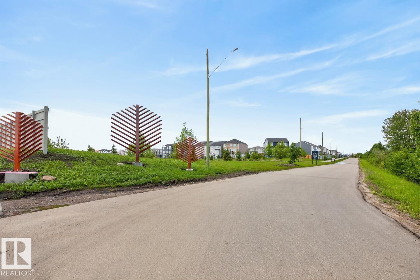Paved road bordered by green spaces and residential properties - 1022 Hearthstone Boulevard, Sherwood Park, AB