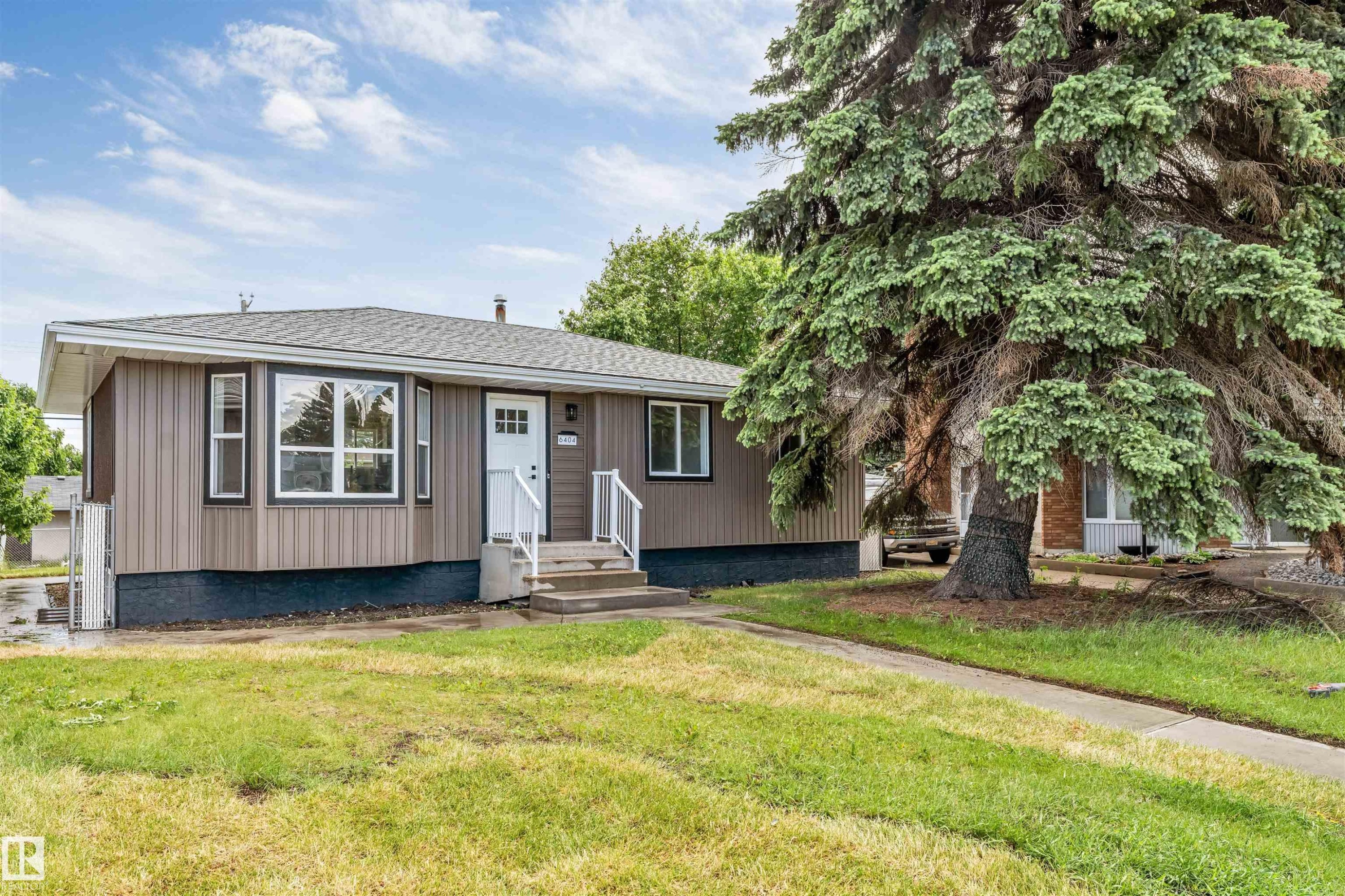 Ranch-style residence featuring vertical siding, a bay window, and a gabled roof - 6404 88 Avenue, Edmonton, AB